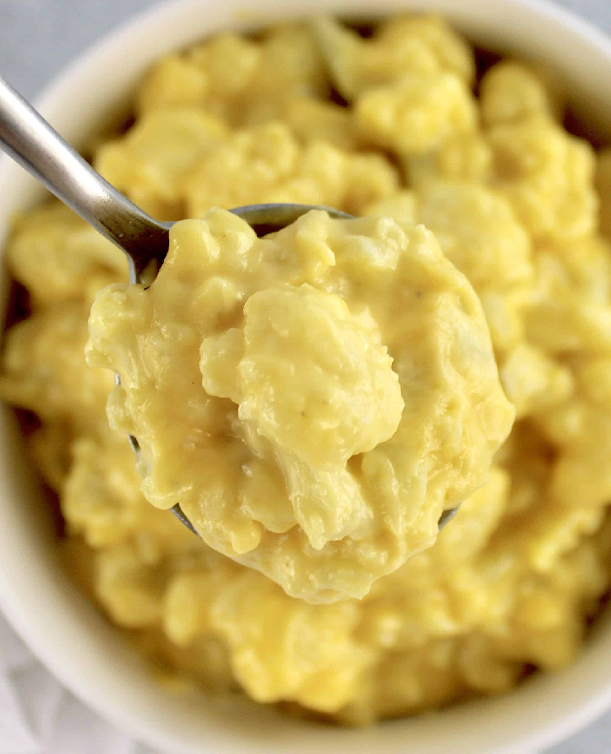 spoonful of Cauliflower Mac and Cheese held up over bowl