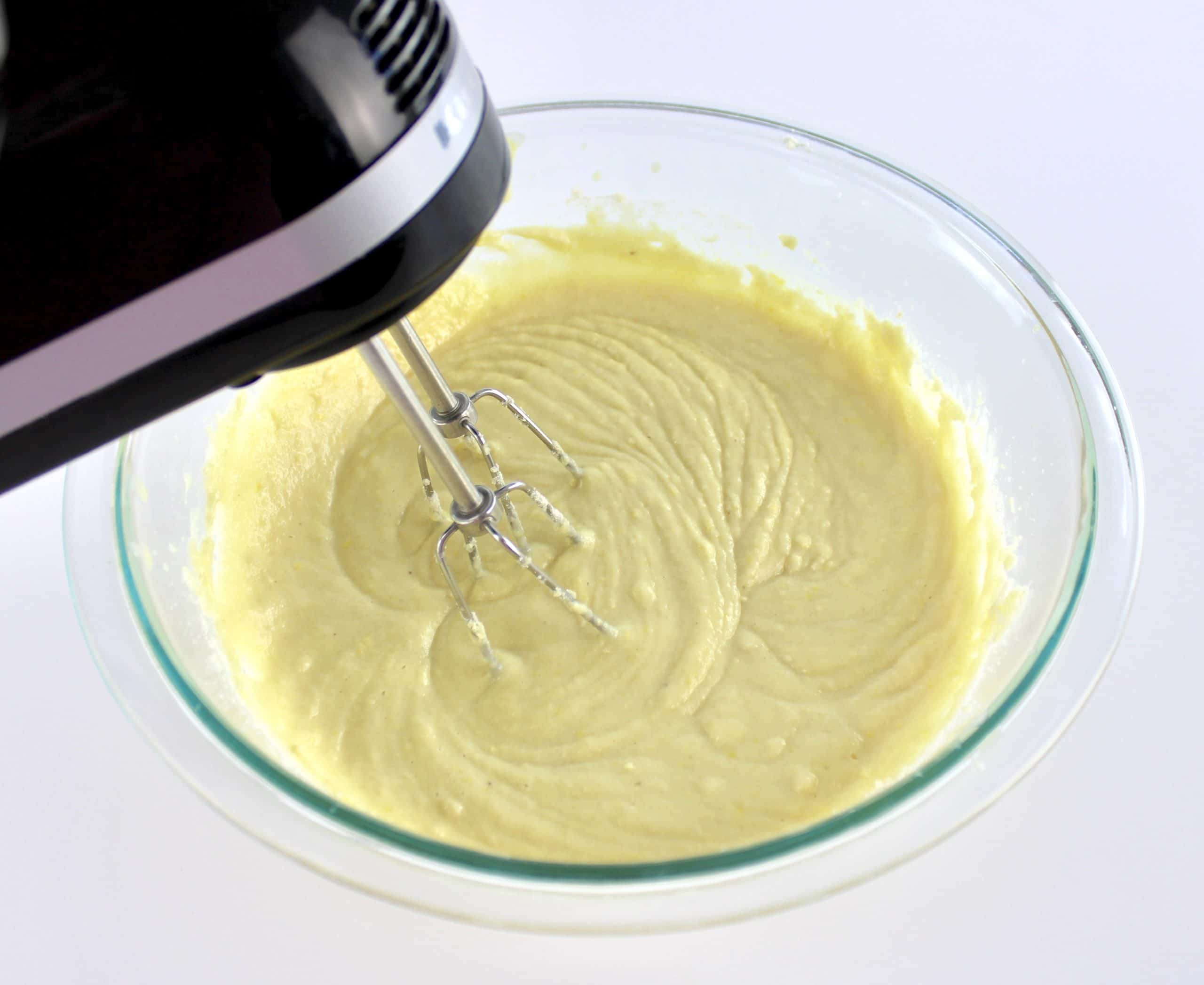 Lemon Cupcakes batter in glass bowl being mixed with hand mixer
