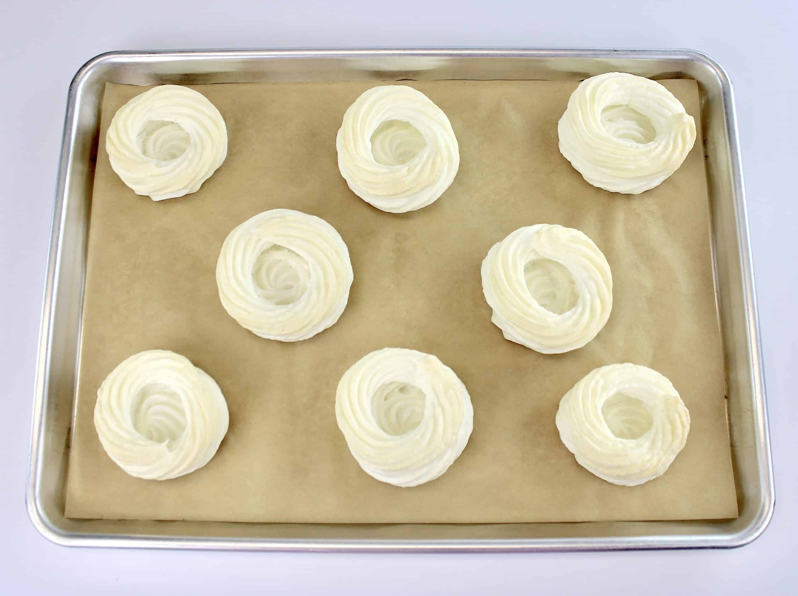 8 mini pavlovas baked on sheet pan lined with parchment paper