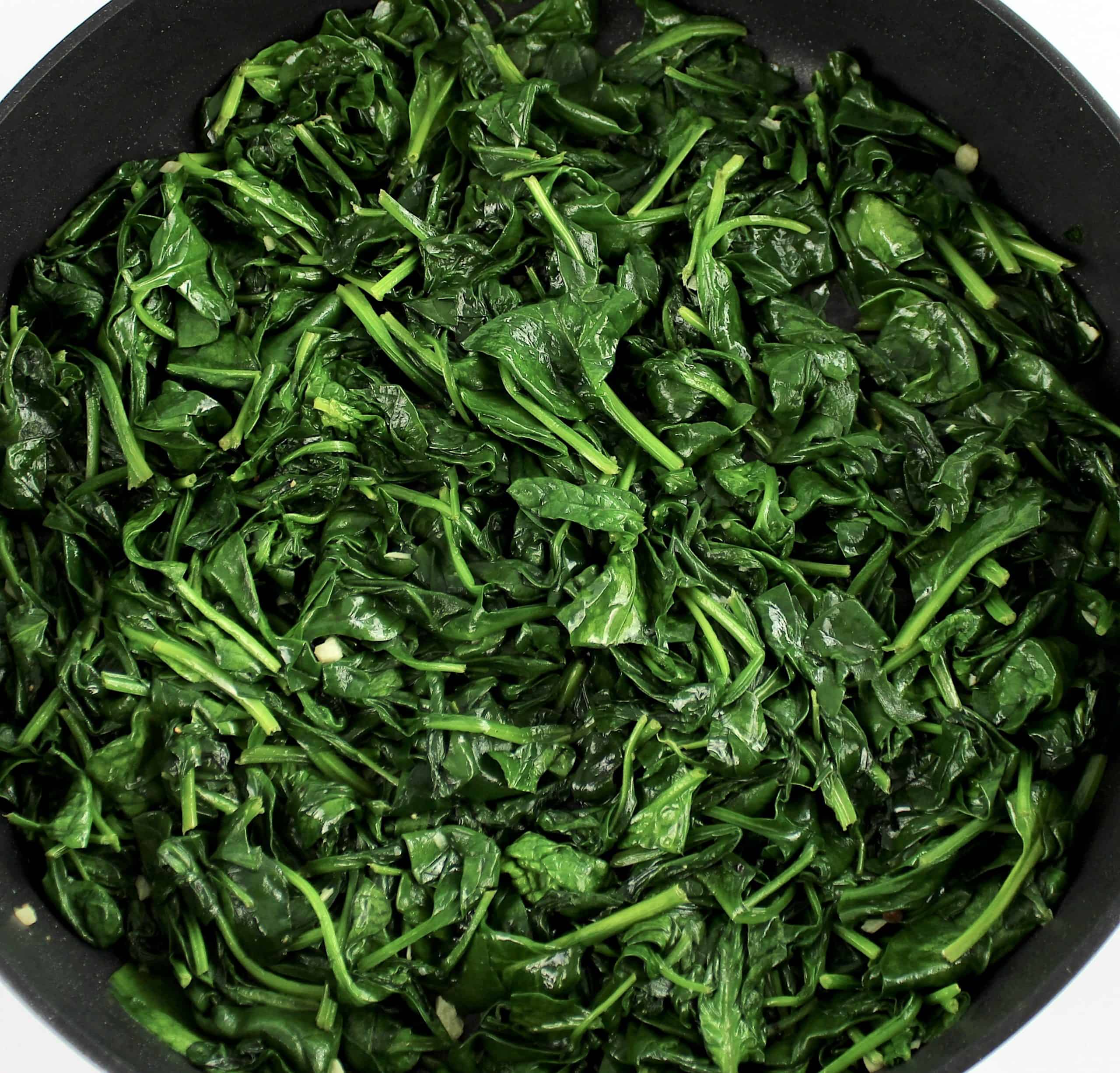 Sautéed spinach in skillet with garlic
