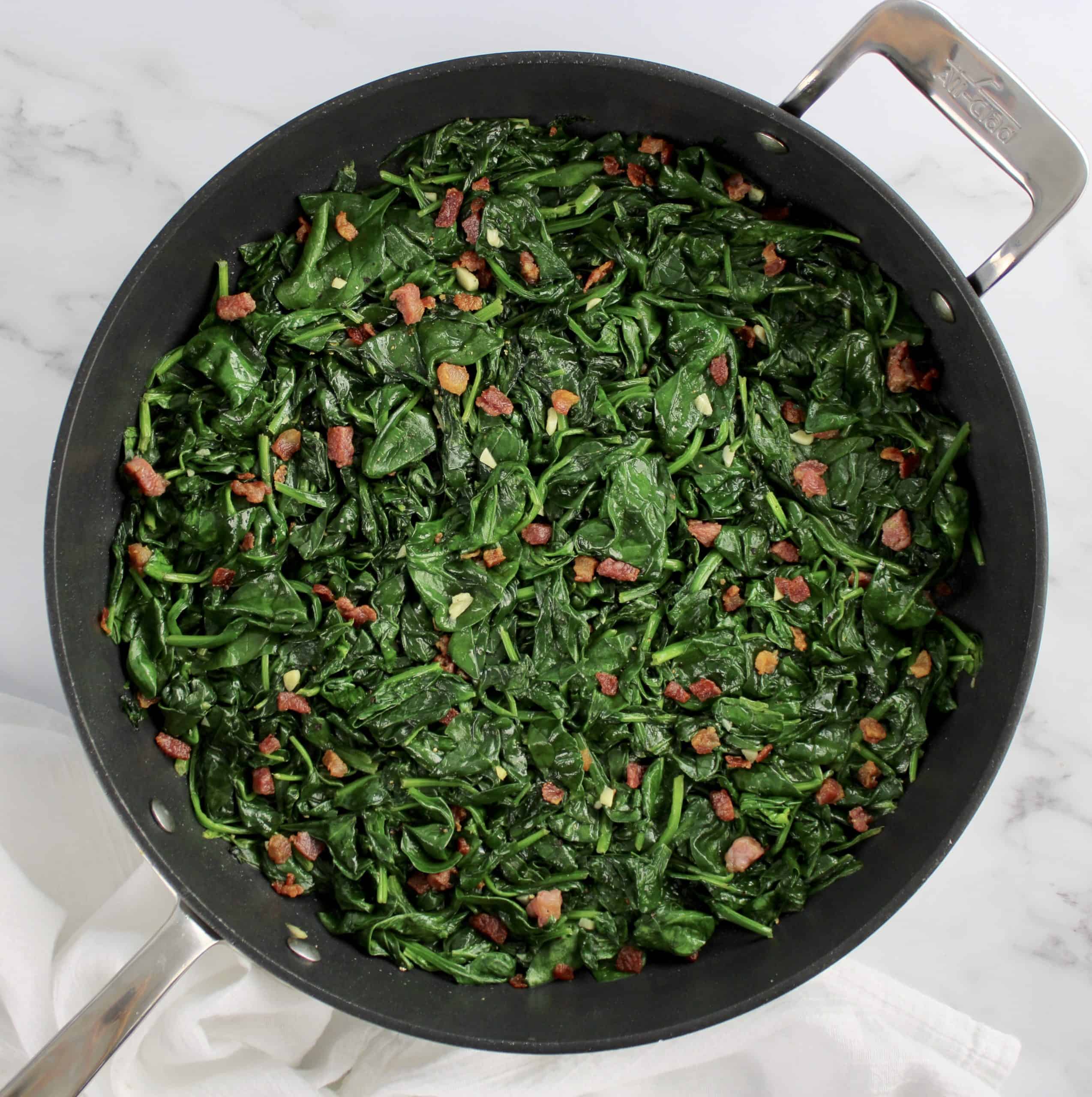 overhead view of Sautéed Spinach with Pancetta in skillet