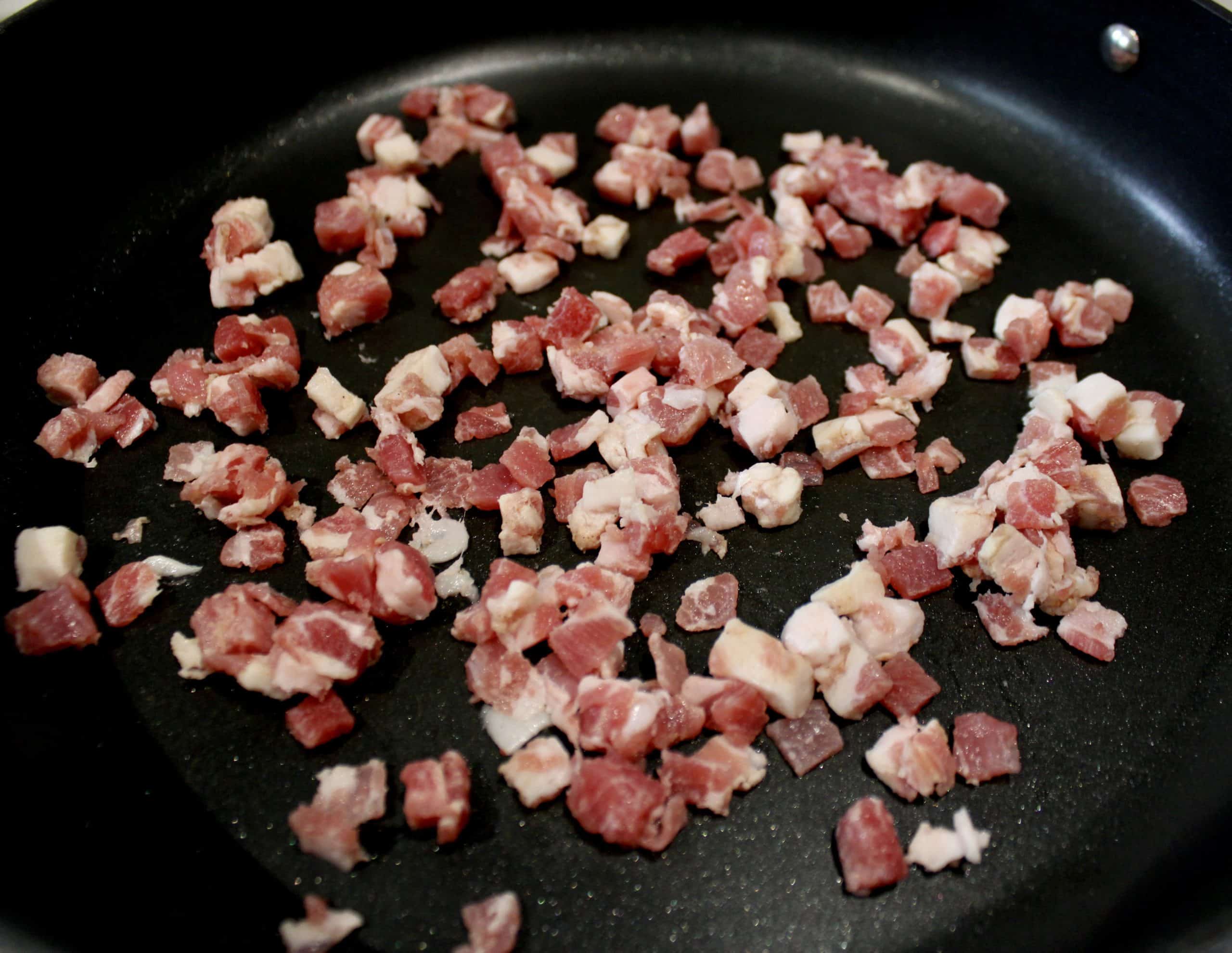 diced pancetta frying in skillet