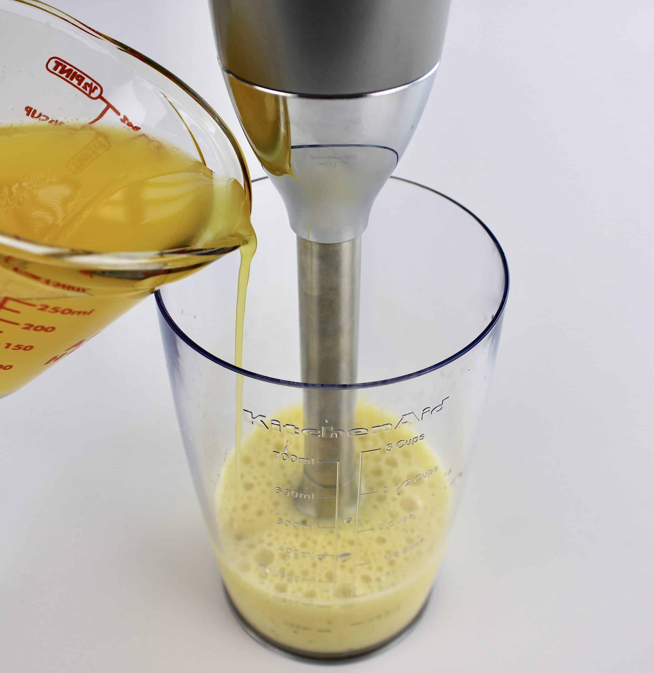 melted butter being streamed into egg mixture in immersion blender