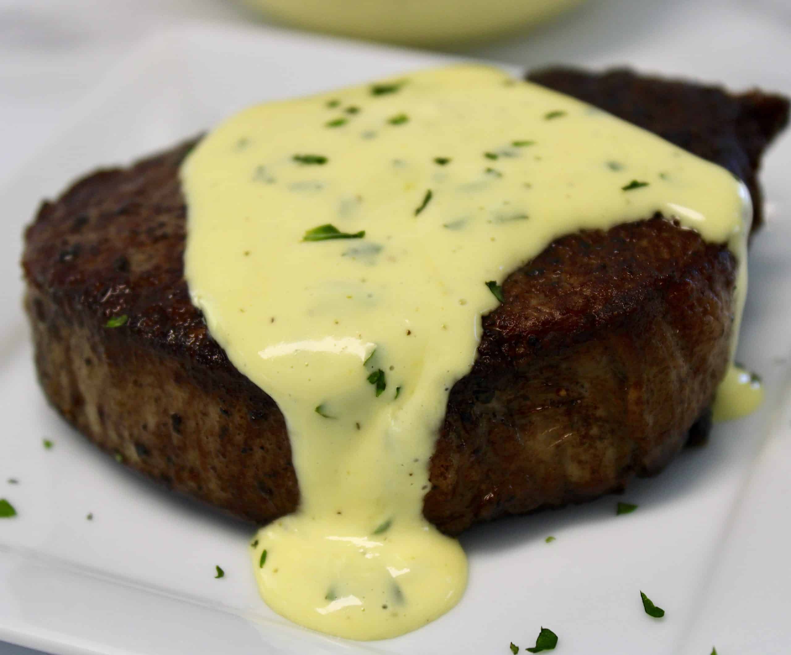 closeup of filet mignon with béarnaise sauce on top
