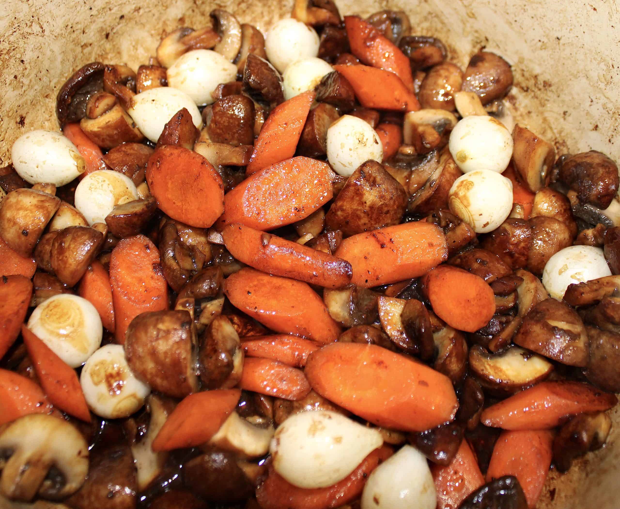 cooked carrots pearl onions and mushrooms in pot