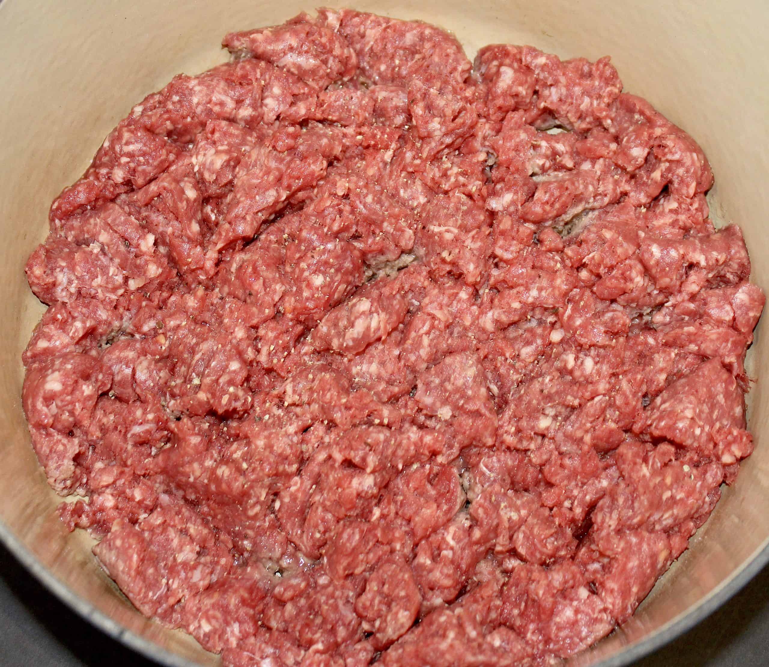 raw ground beef cooking in a pot