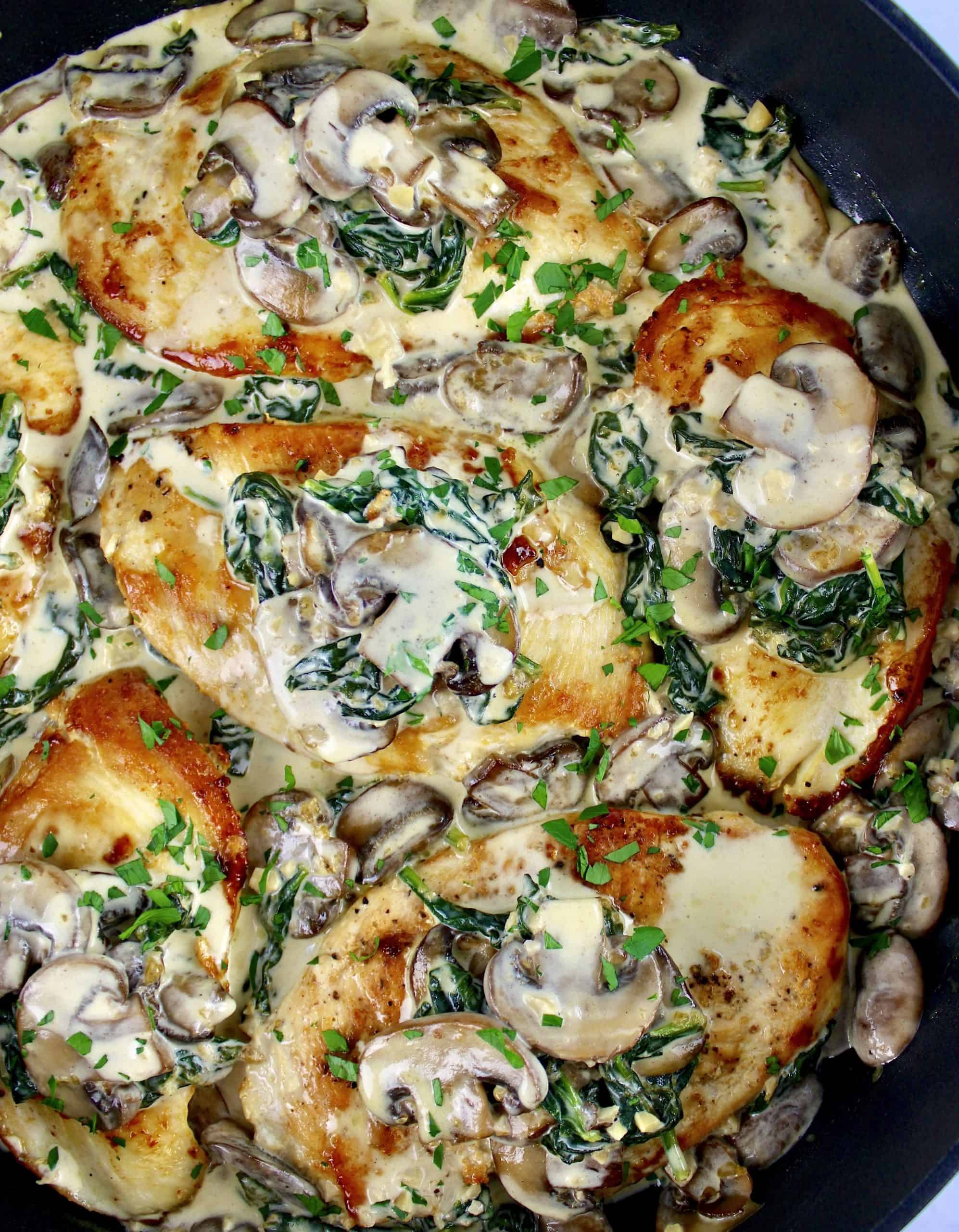 Chicken Florentine in skillet with mushrooms and spinach on top