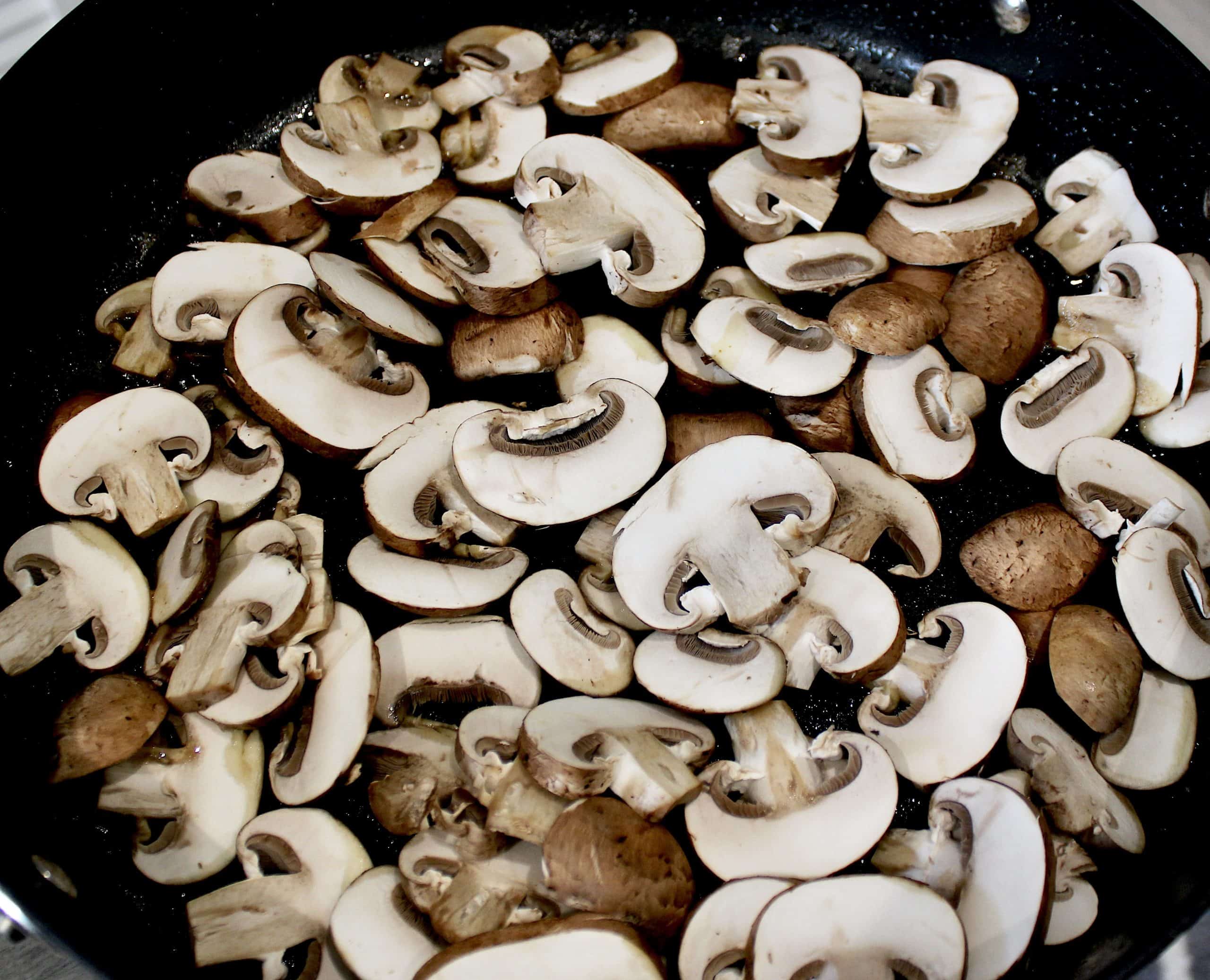 sliced baby bella mushrooms in skillet uncooked