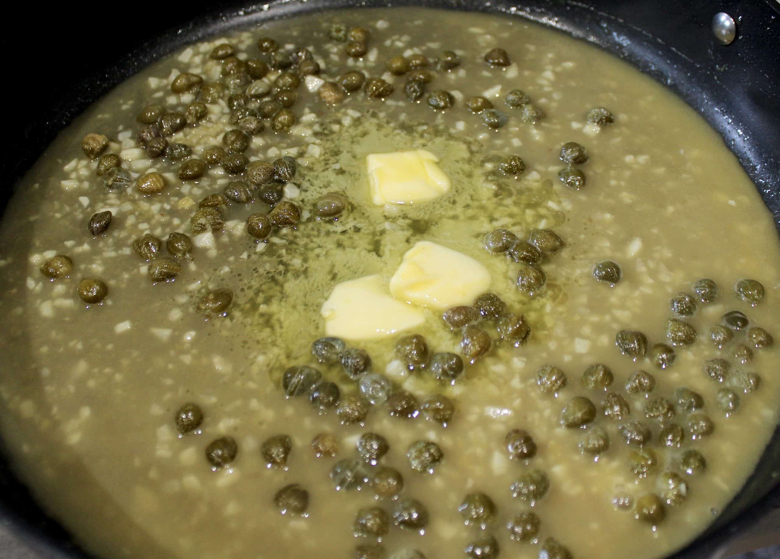 piccata sauce with capers in skillet with butter in the center
