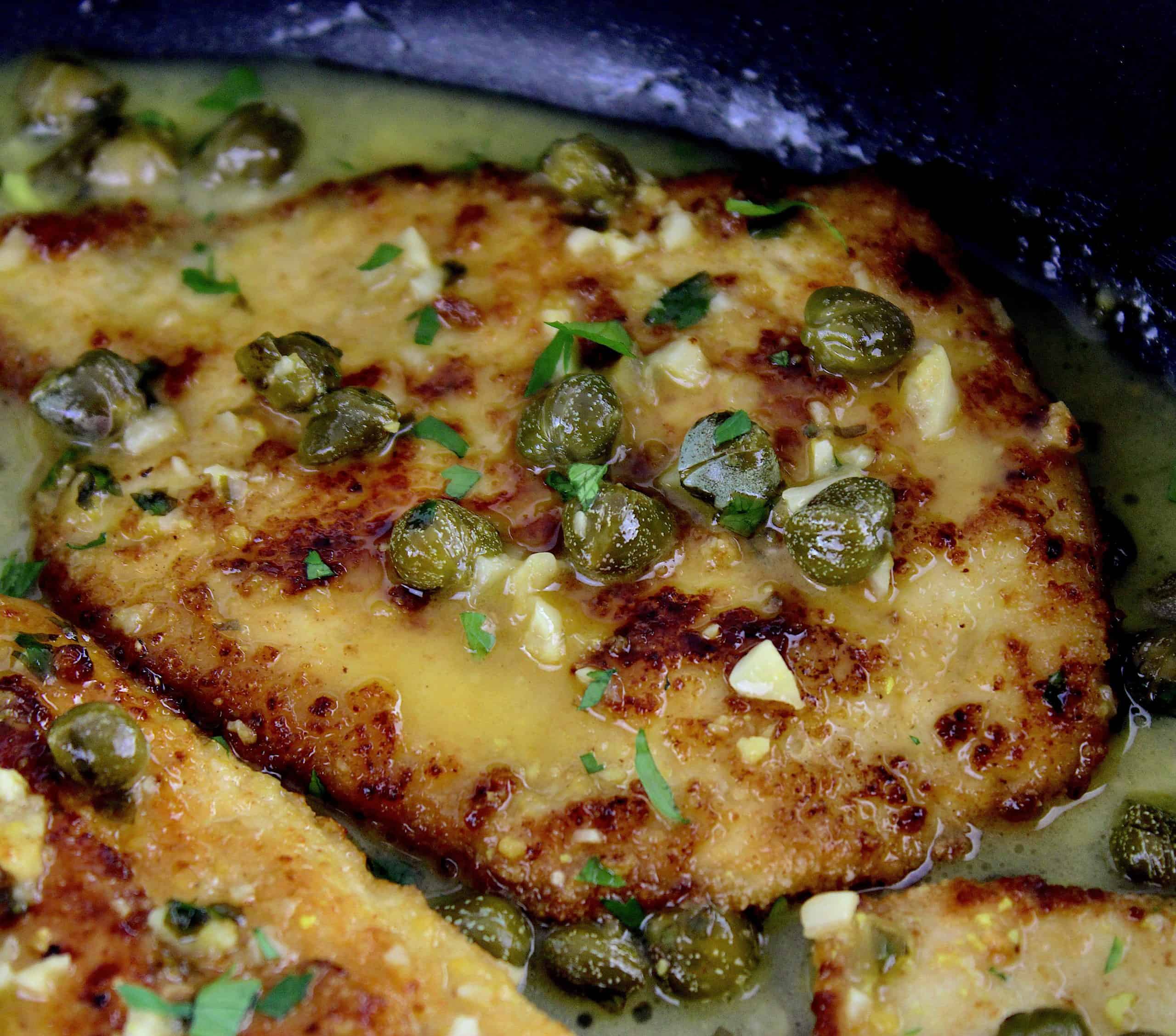 closeup of piece of Chicken Piccata in skillet