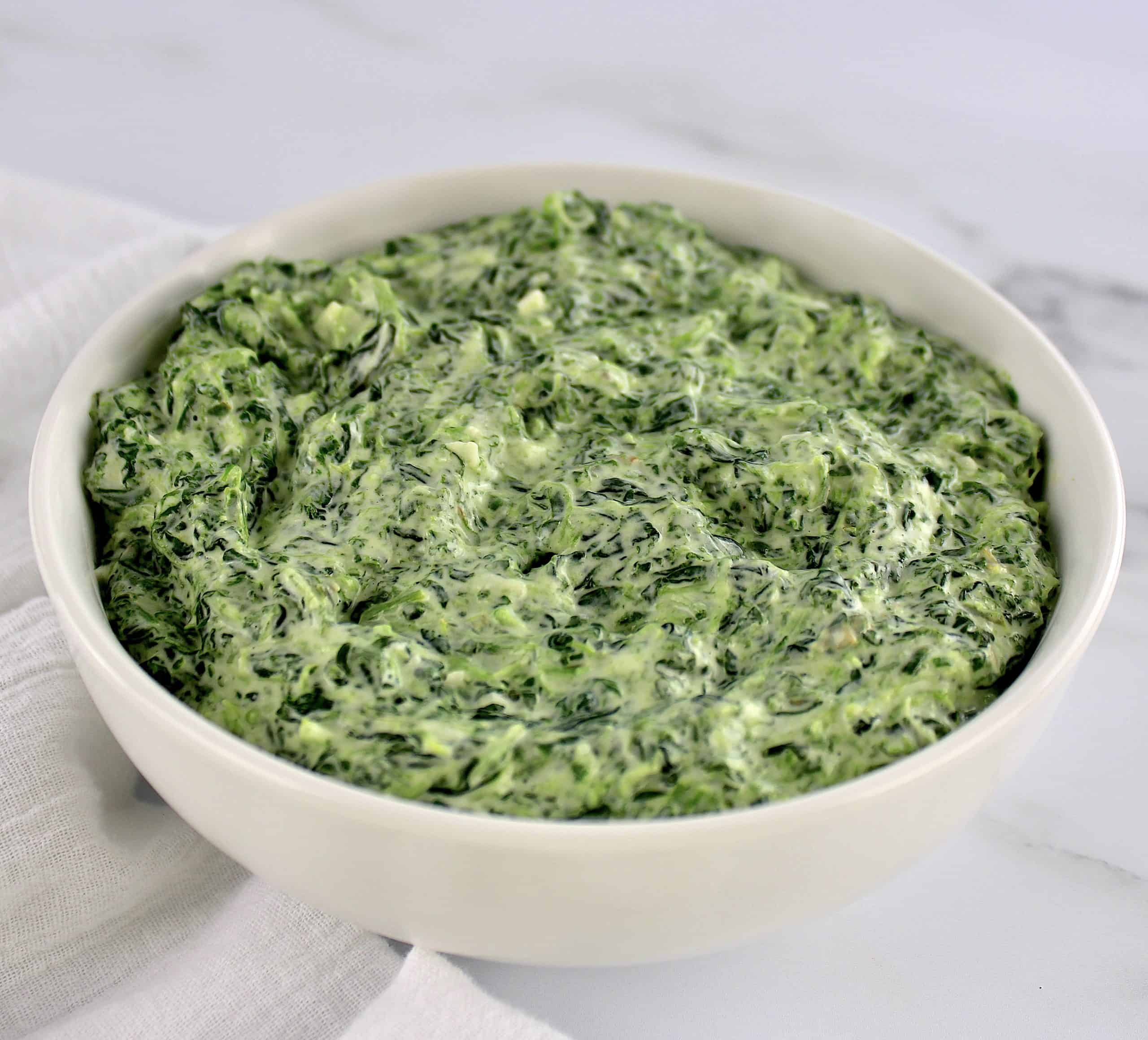 creamed spinach in white bowl