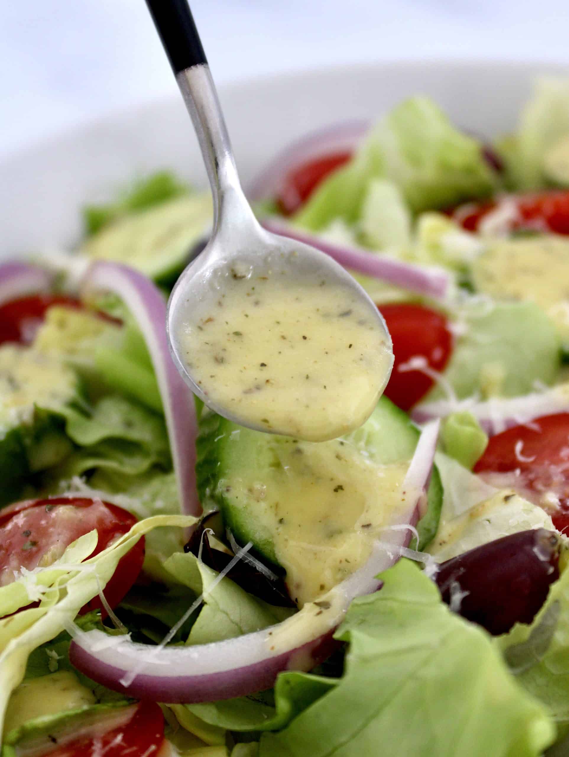 Homemade Italian Dressing being spooned over salad