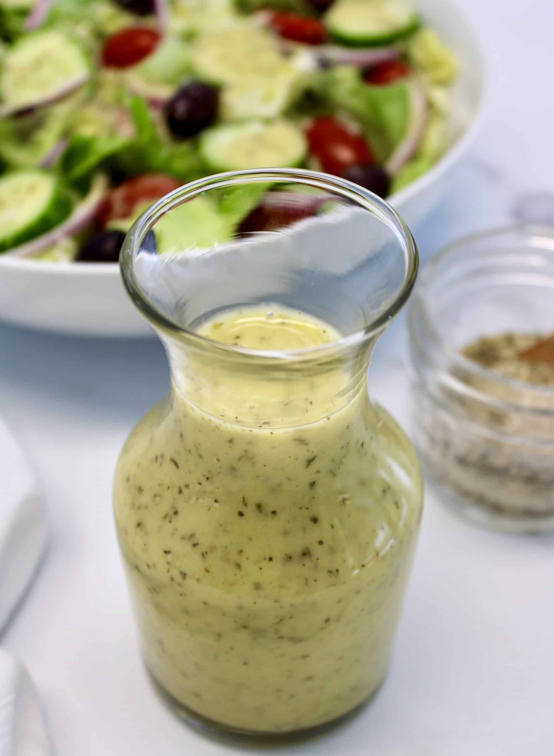 cruet of Homemade Italian Dressing with salad in background