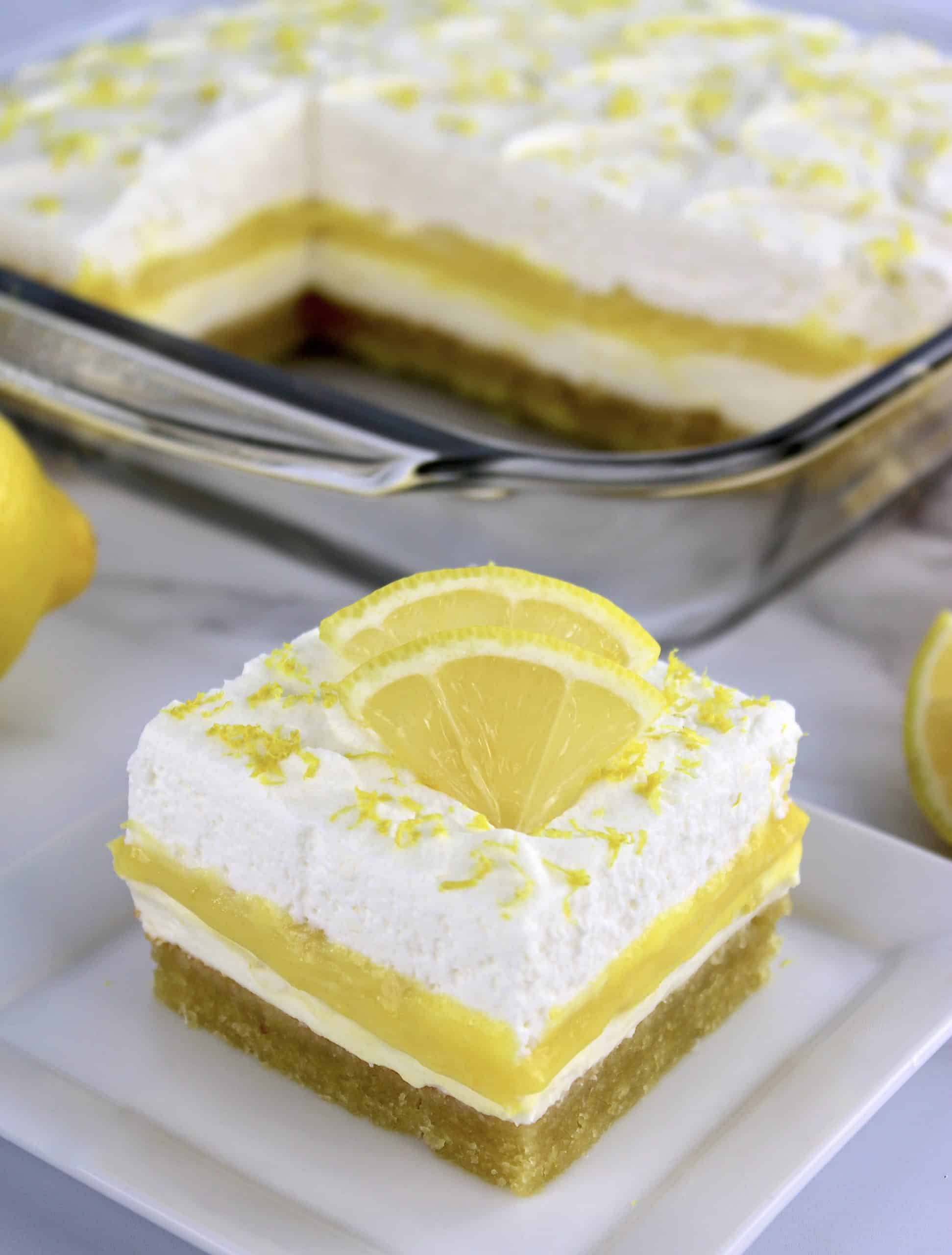 slice of lemon lush on white plate with casserole in background
