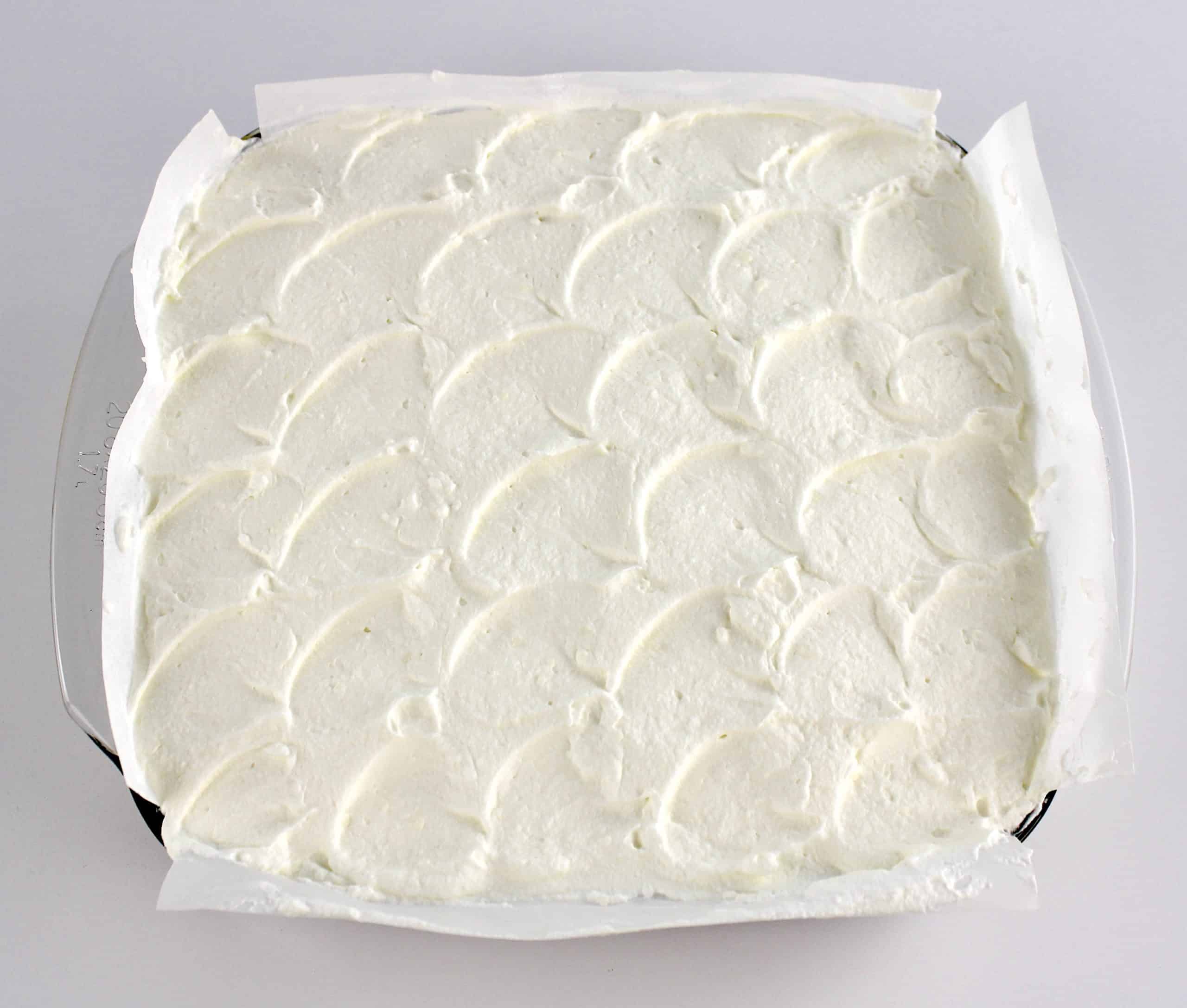 Keto Lemon Lush whipped topping layer in glass dish with parchment paper
