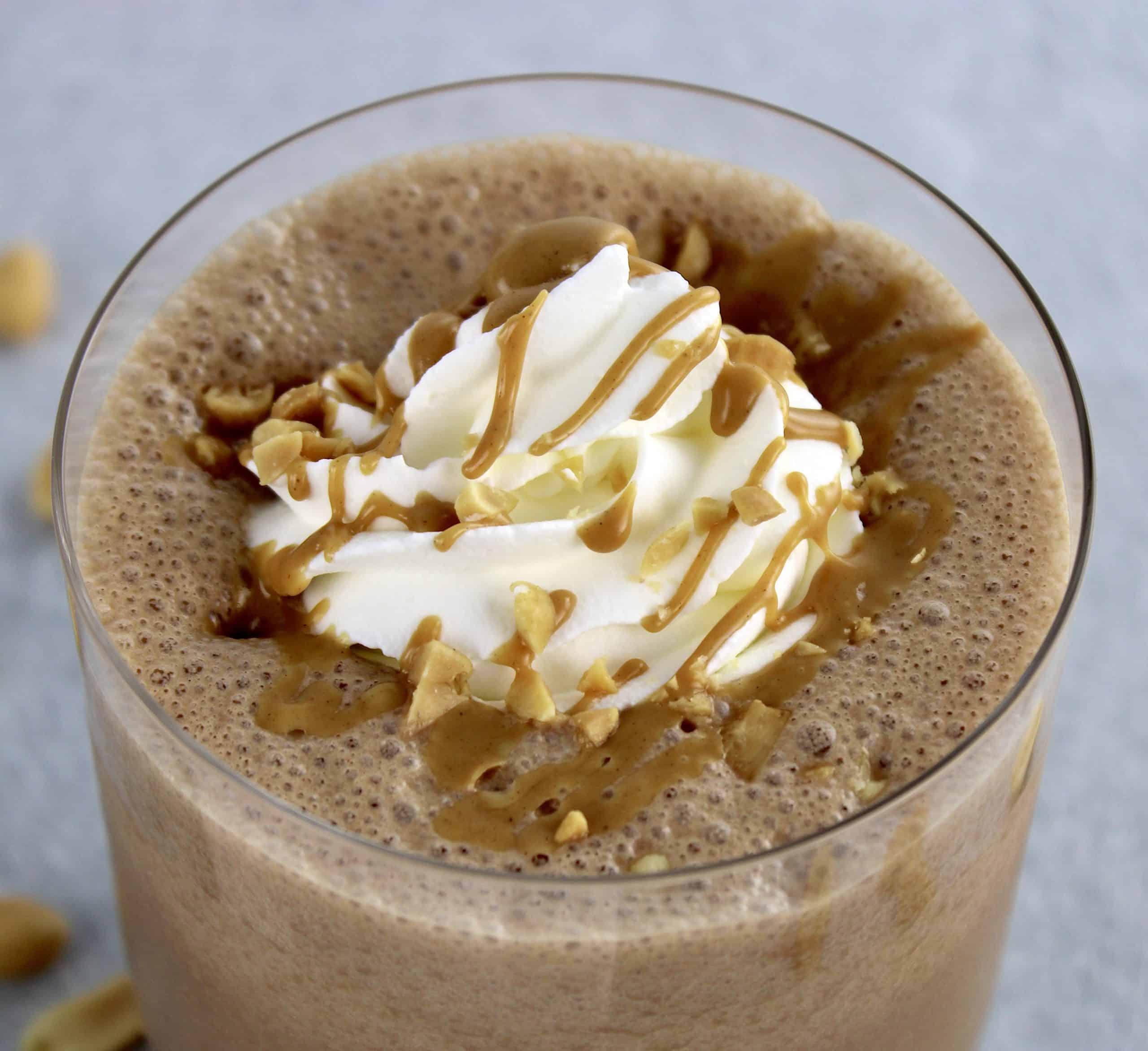 overhead view of Keto Peanut Butter Smoothie with whip cream and peanut butter drizzle on top