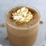 Keto Peanut Butter Smoothie in glass with whip cream and drizzle of peanut butter on top