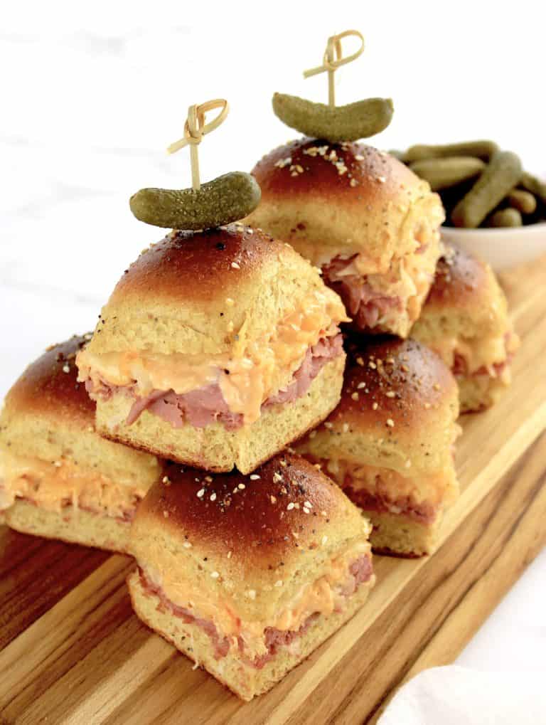 Keto Reuben Sliders stacked on cutting board with pickles on top