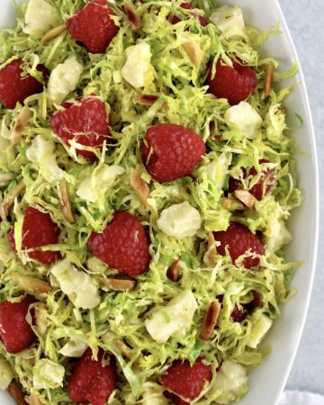 Shaved Brussels Sprouts Salad with raspberries parmesan cheese and slivered almonds
