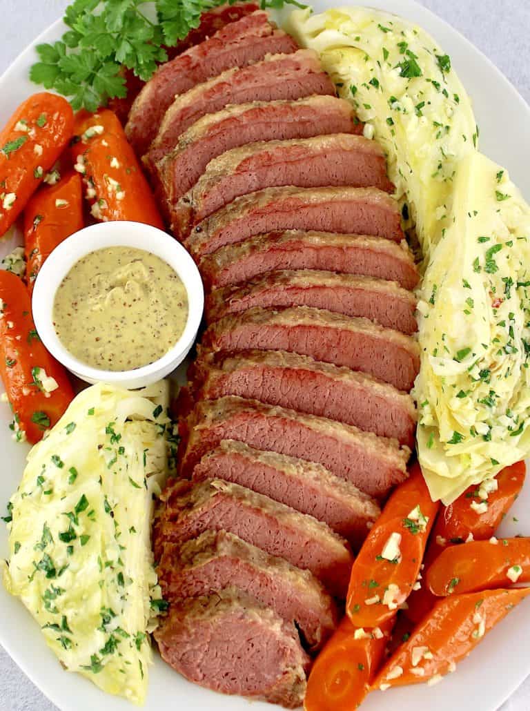 sliced corned beef cabbage and carrots on white platter