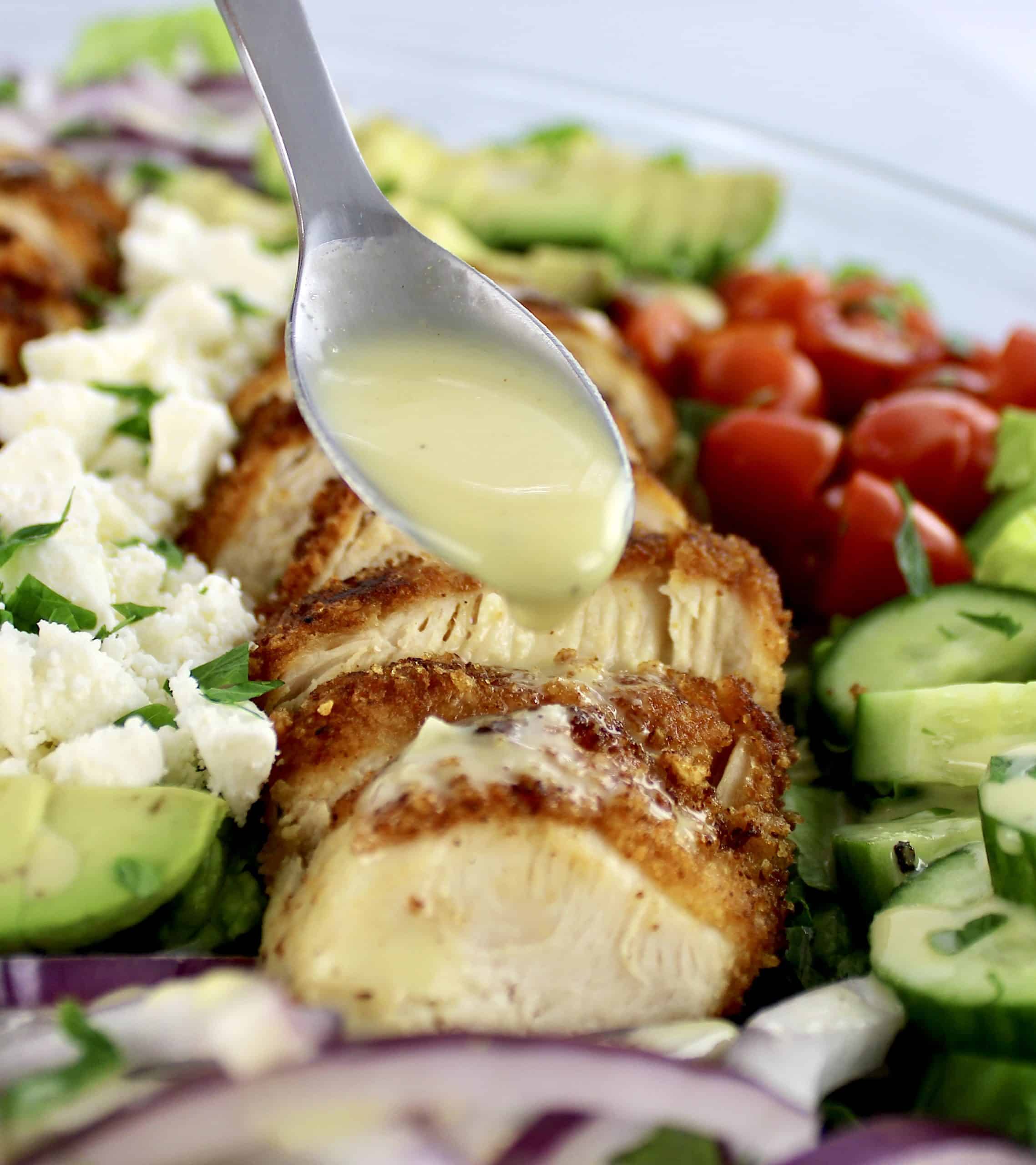 Crispy Chicken Salad with honey mustard dressing being spooned over top