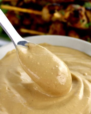 Easy Peanut Sauce in beige bowl with spoon scooping out some