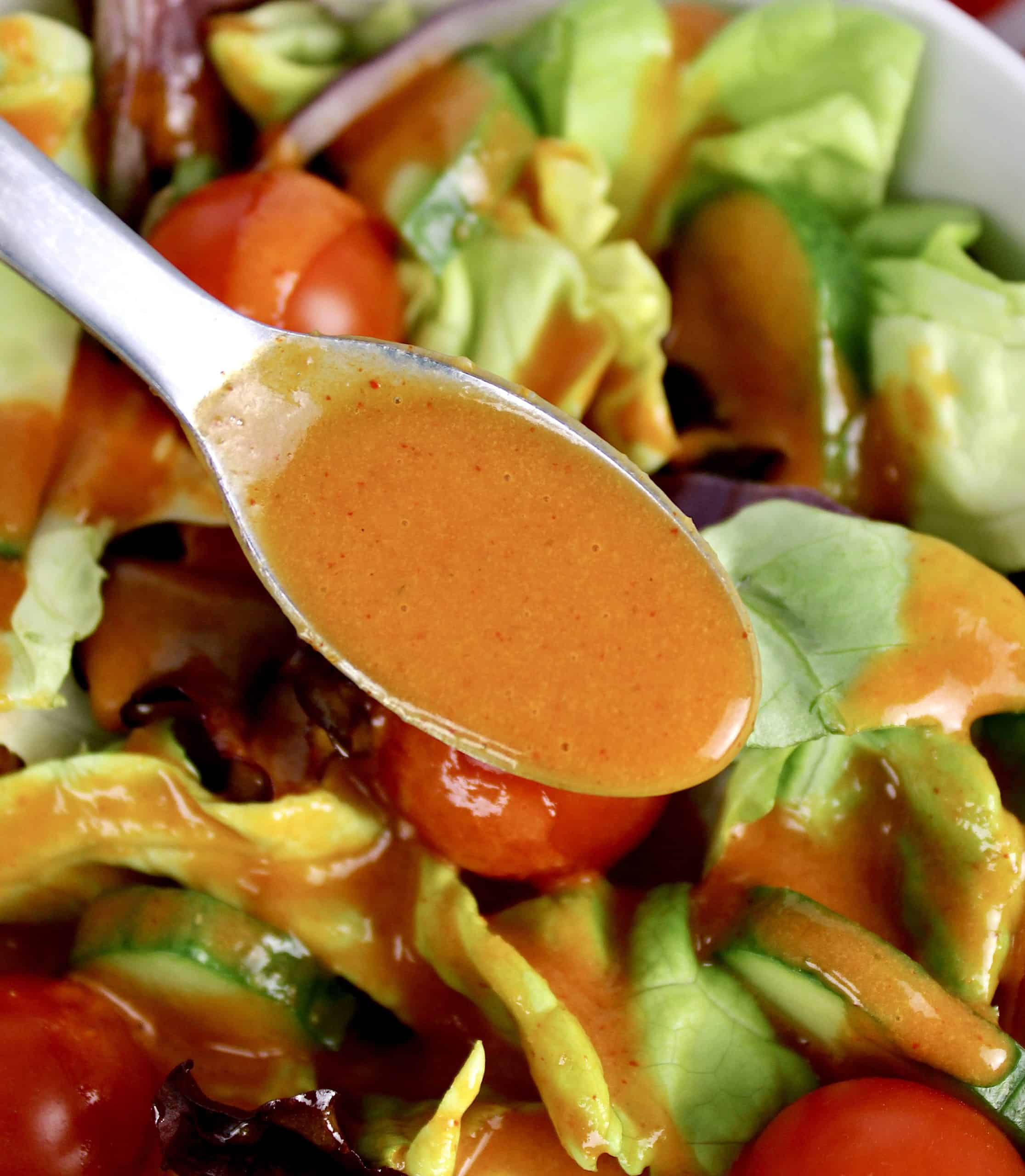 spoonful of catalina dressing held over salad