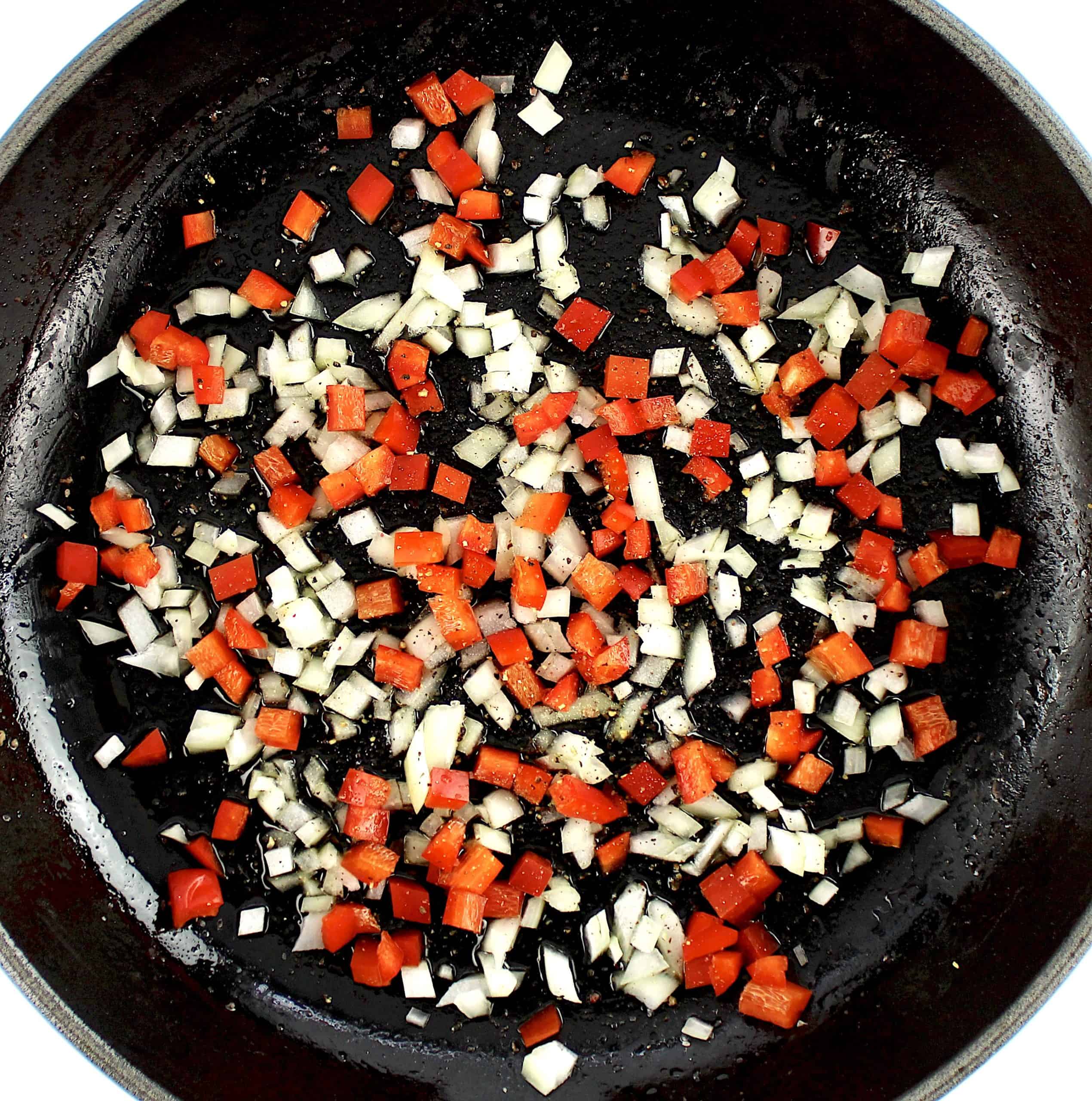 diced peppers and onions cooking in skillet
