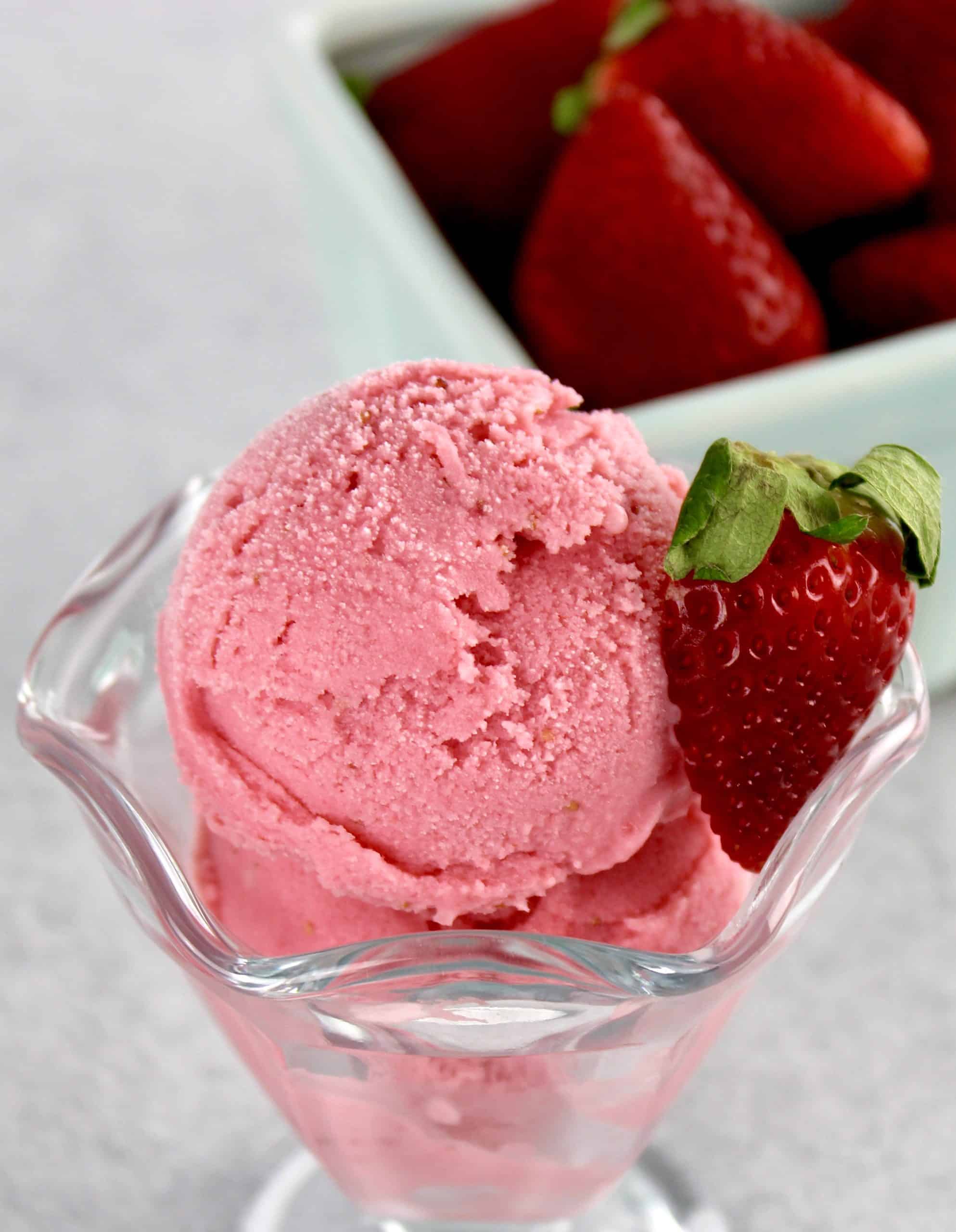 Keto Strawberry Frozen Yogurt in glass with cut strawberry on side
