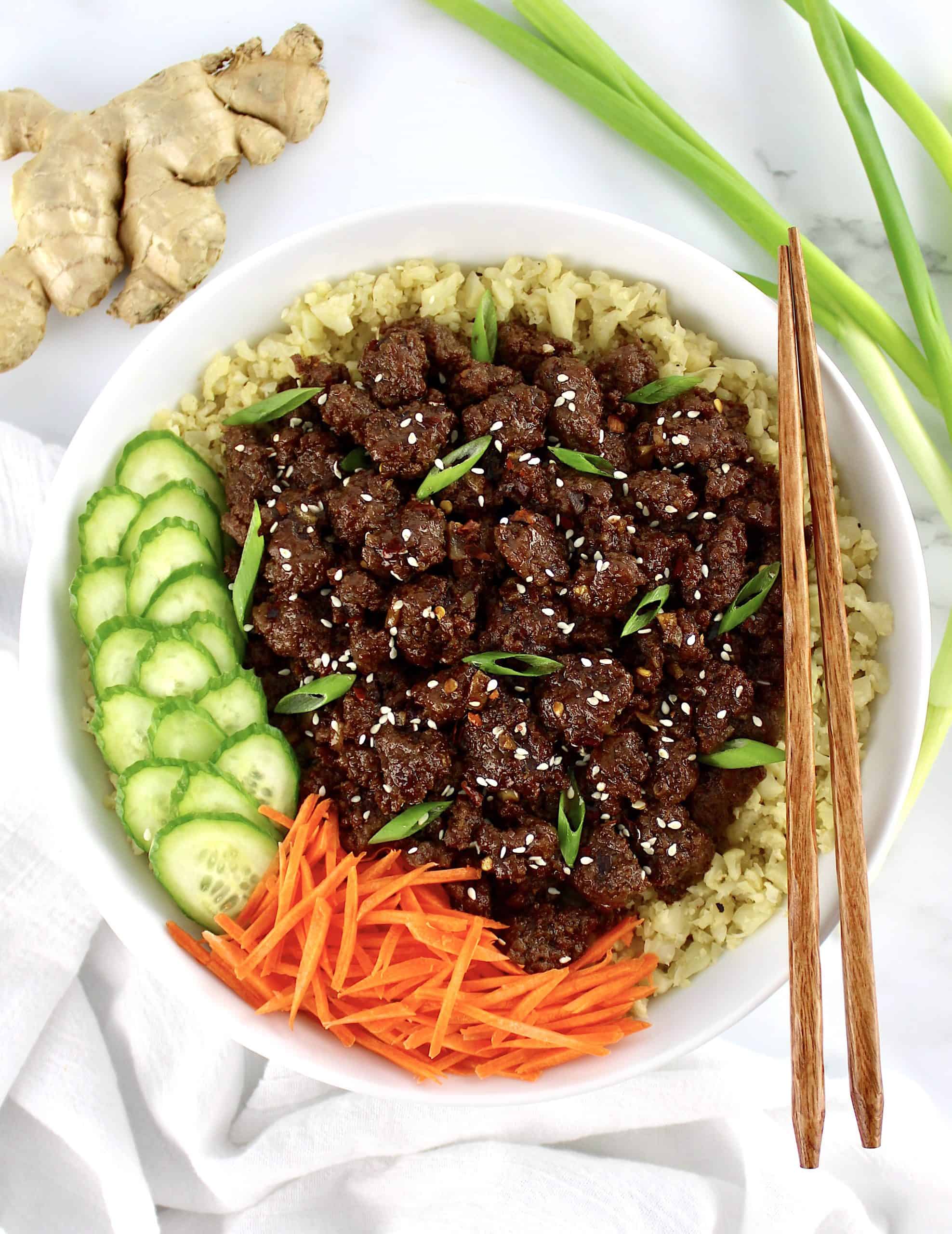 Korean Beef Bowl with cauliflower rice shredded carrots and sliced cucumbers