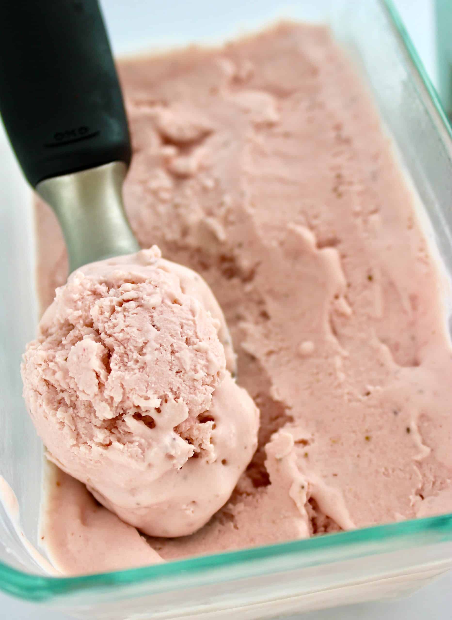 No Churn Keto Strawberry Ice Cream in glass container with ice cream scoop