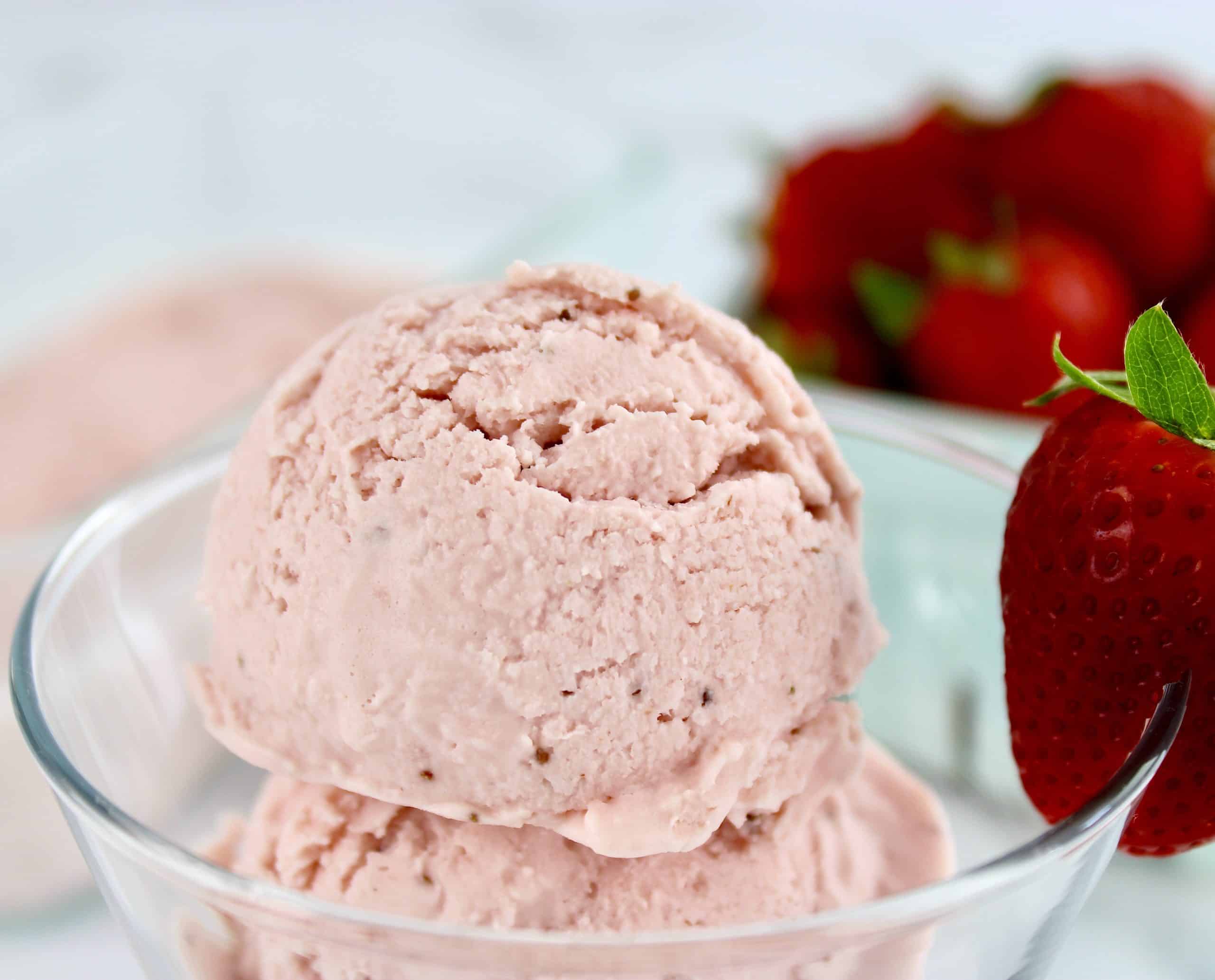 closeup of scoop of strawberry ice cream in glass