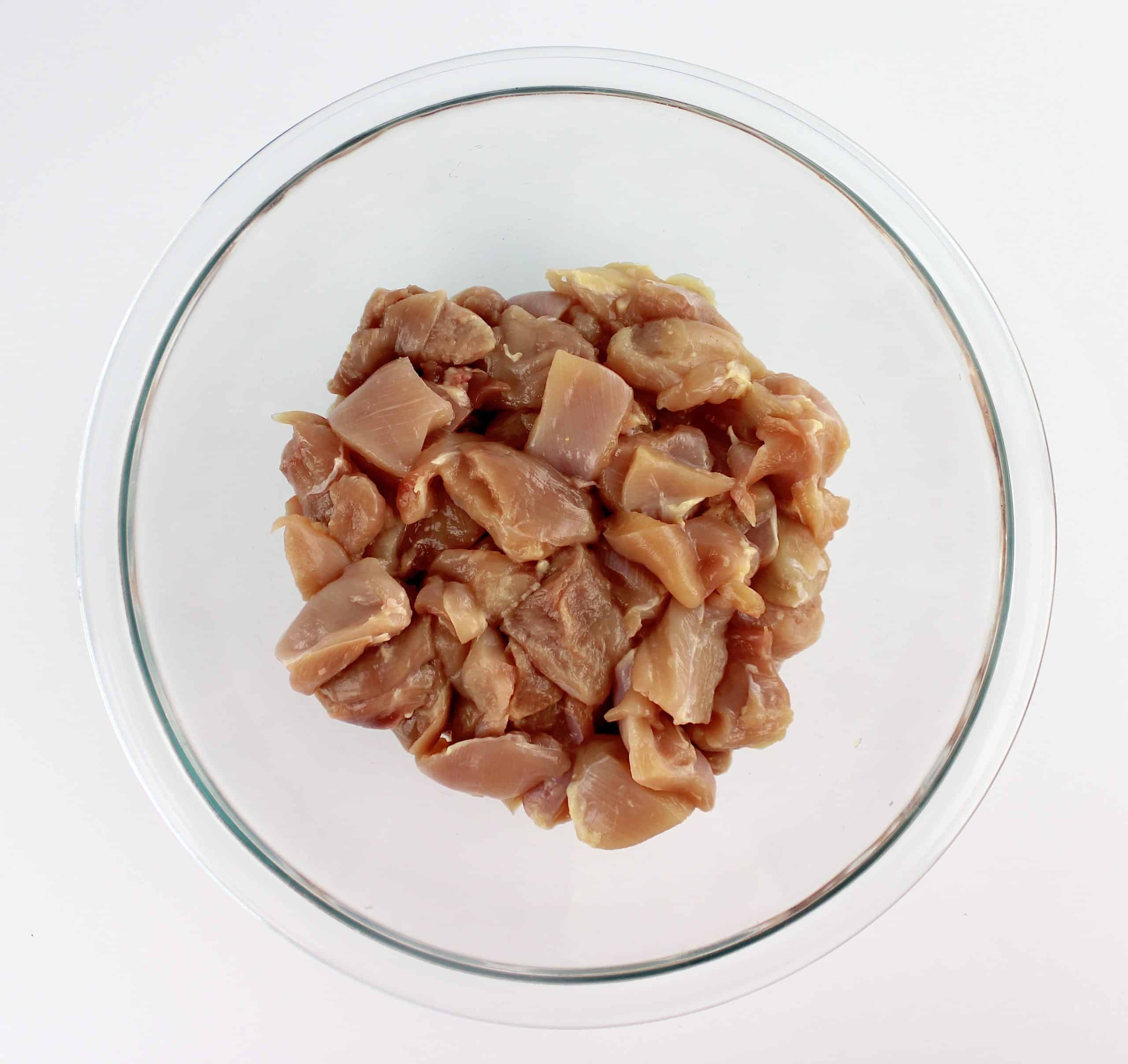 chunks of chicken thighs in glass bowl