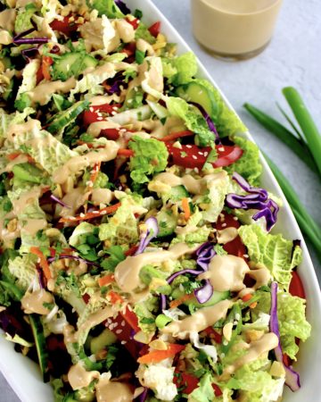 Thai Crunch Salad with Peanut Dressing on top in white bowl