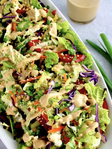 Thai Crunch Salad with Peanut Dressing on top in white bowl