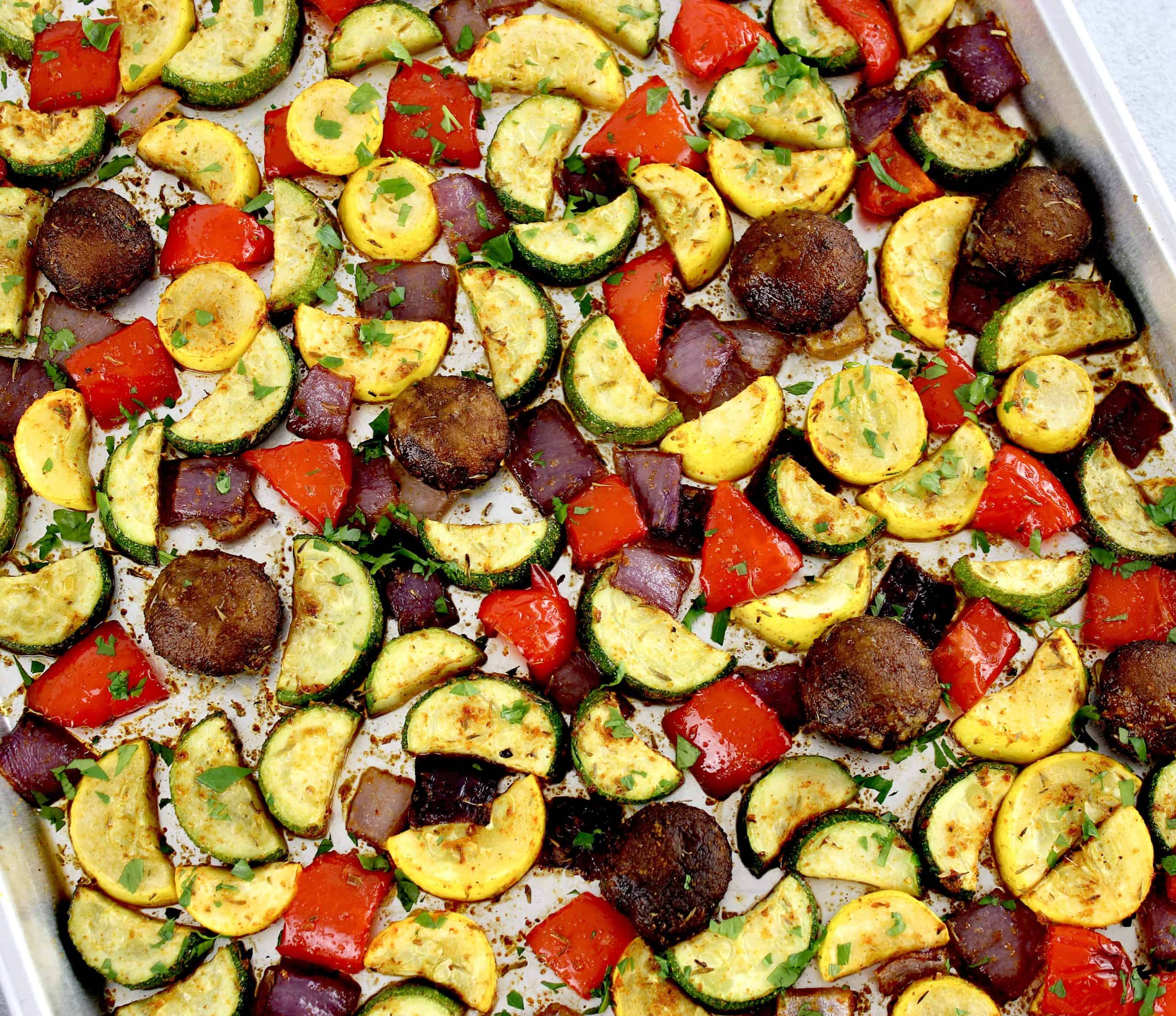closeup of Oven Roasted Vegetables on baking sheet with chopped parsley on tpp