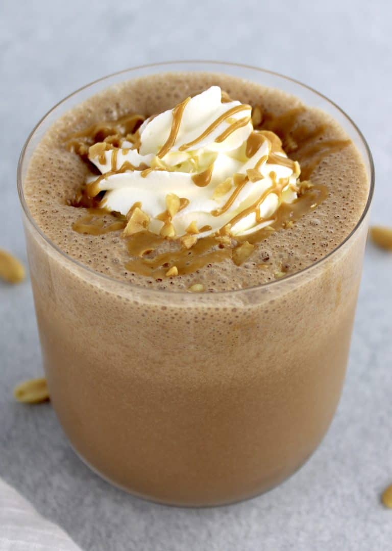Keto Peanut Butter Smoothie in glass with whip cream and drizzle of peanut butter on top