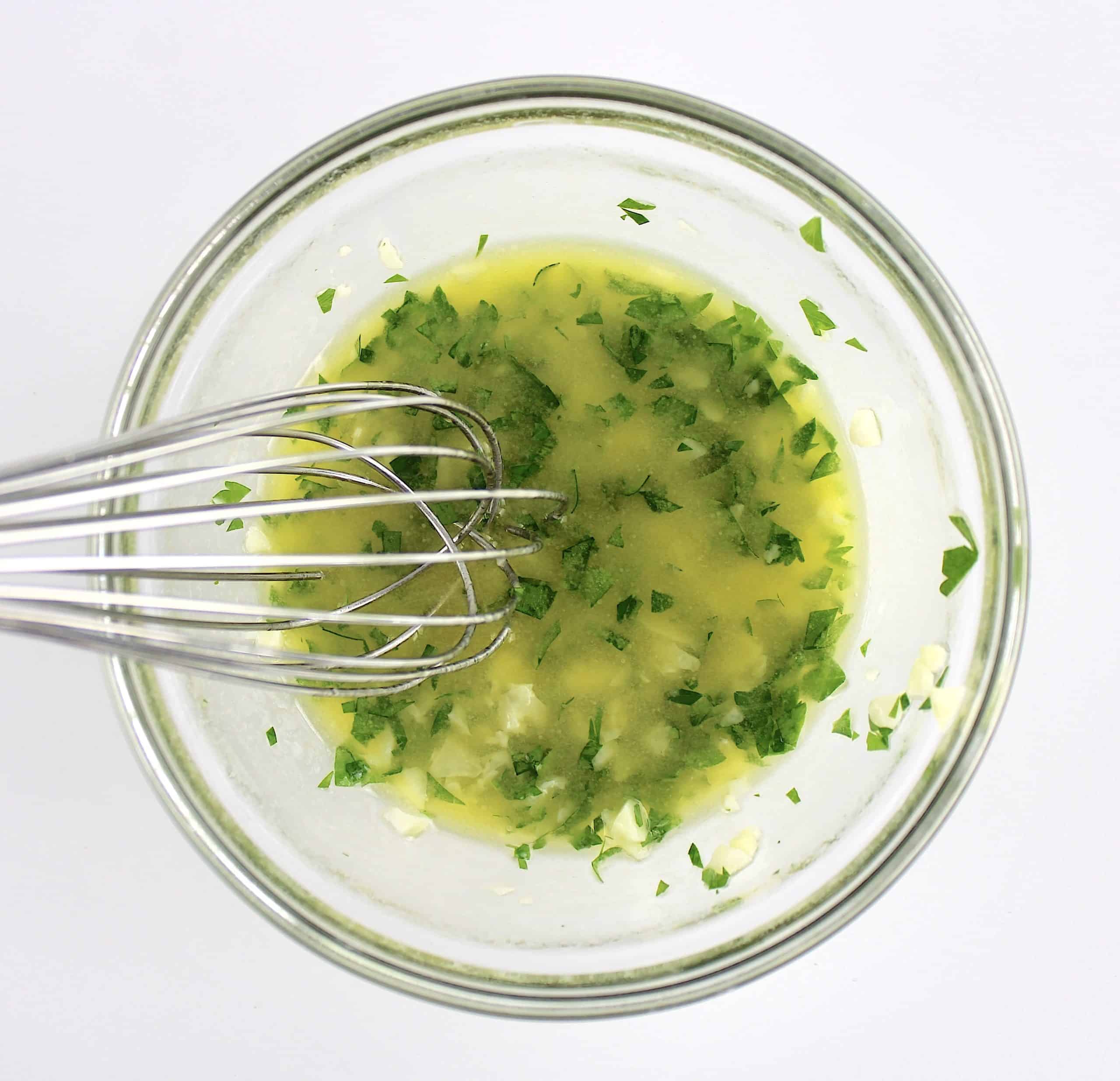 garlic butter in glass bowl with whisk