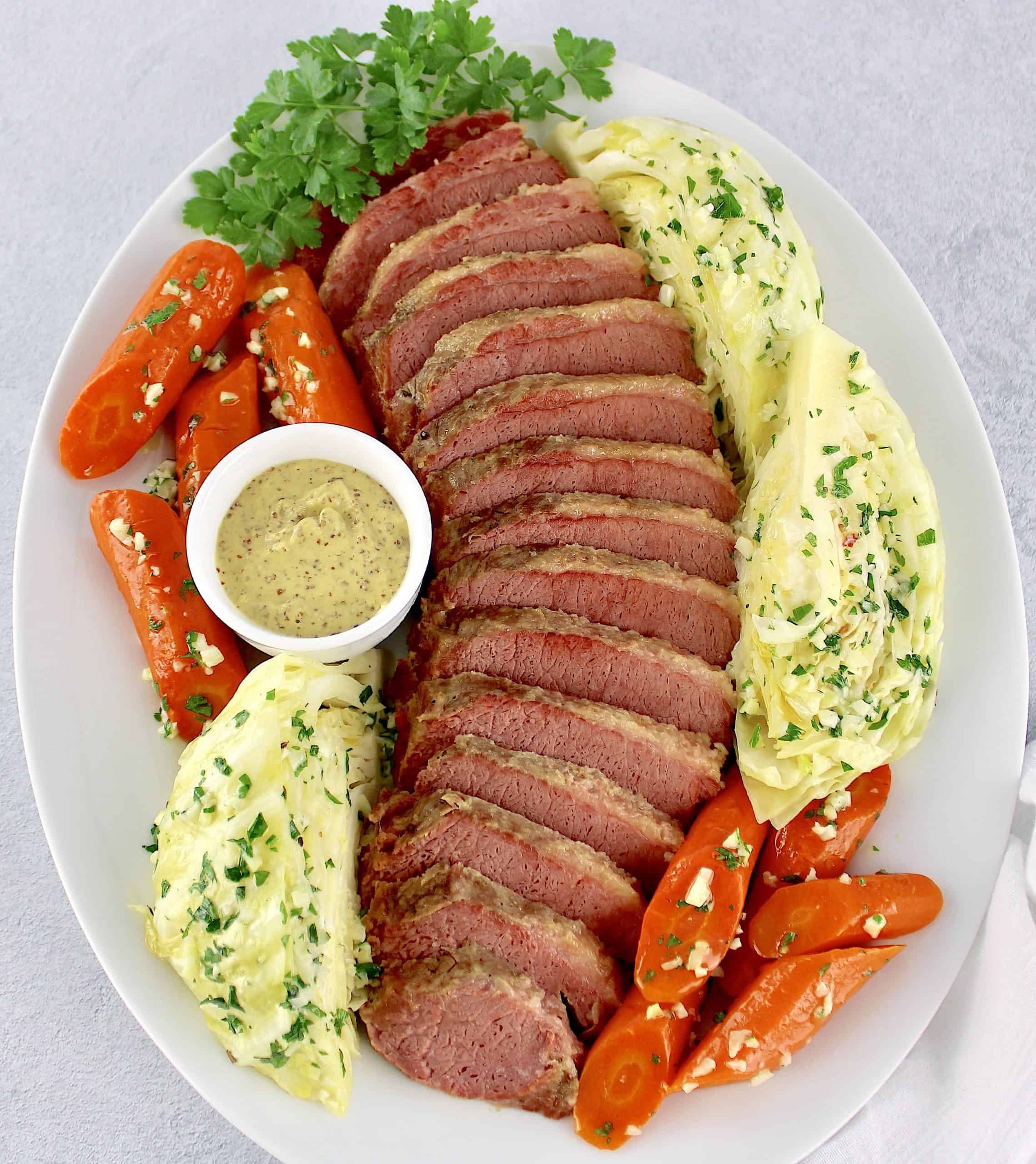 sliced corned beef cabbage and carrots on white platter