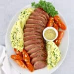 sliced corned beef cabbage and carrots on white platter