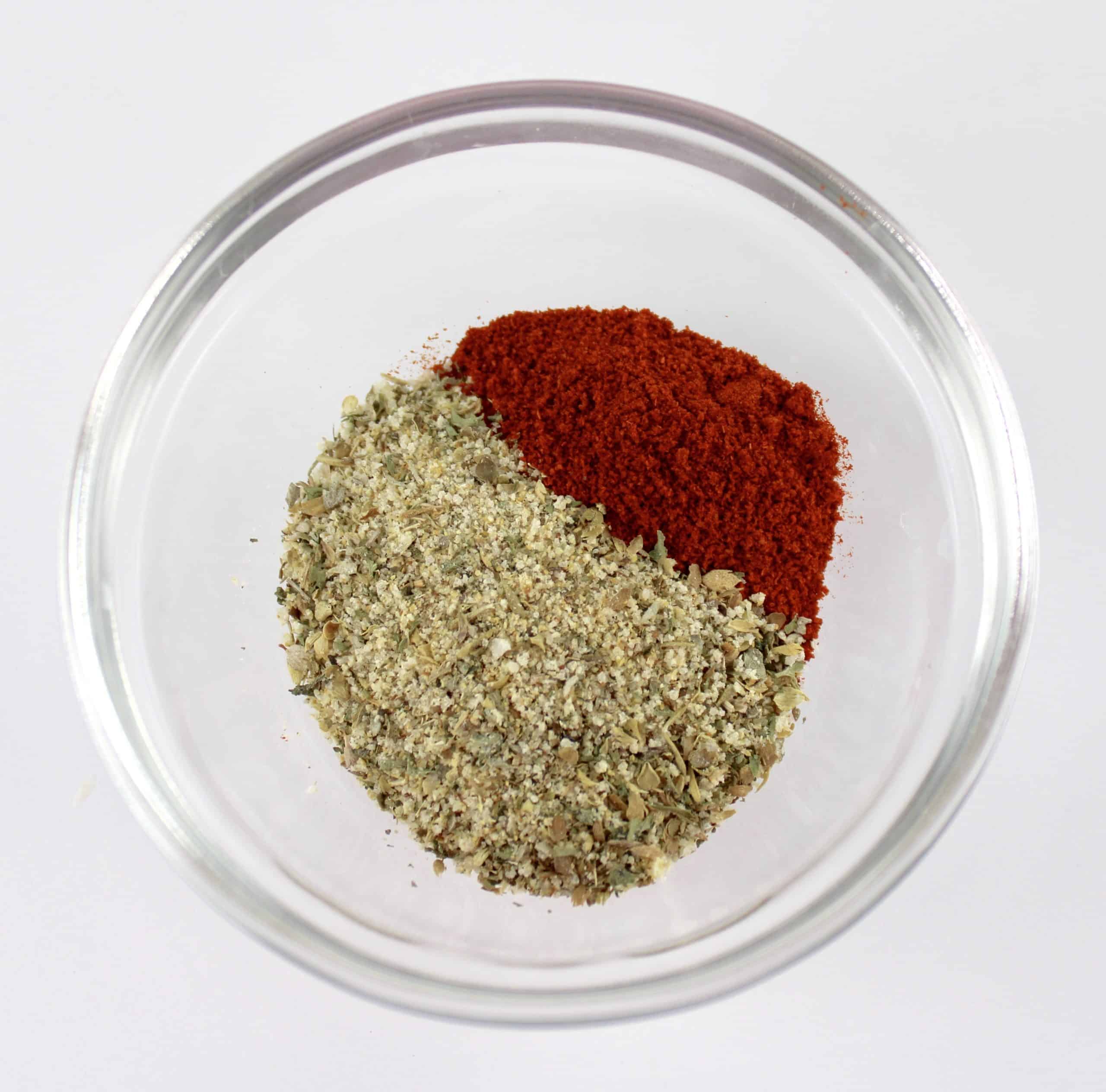 italian seasoning and smoked paprika in glass bowl unmixed