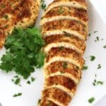 Air Fryer Italian Chicken breast sliced on white plate with parsley garnish
