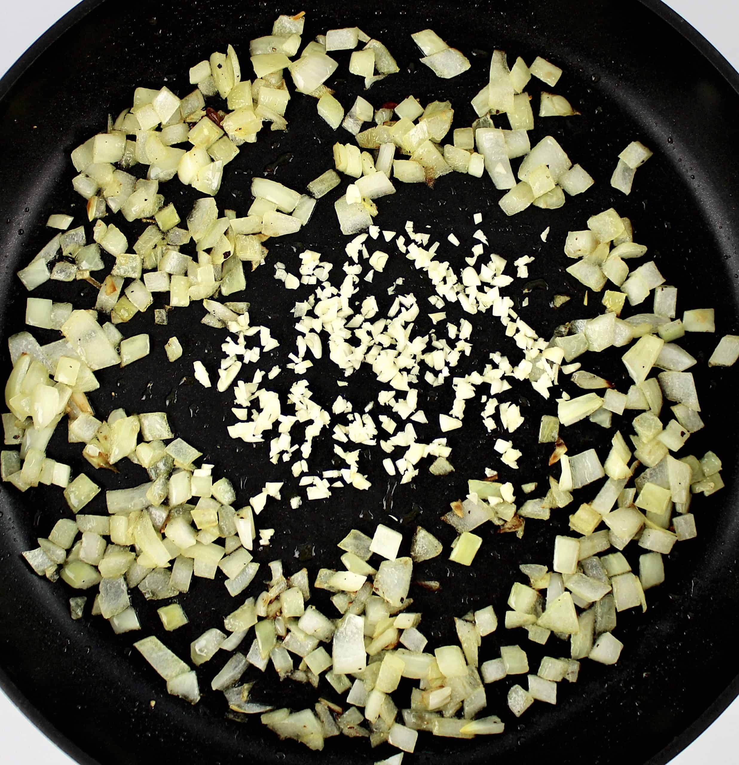 diced onions and minced garlic in center sauteing in skillet