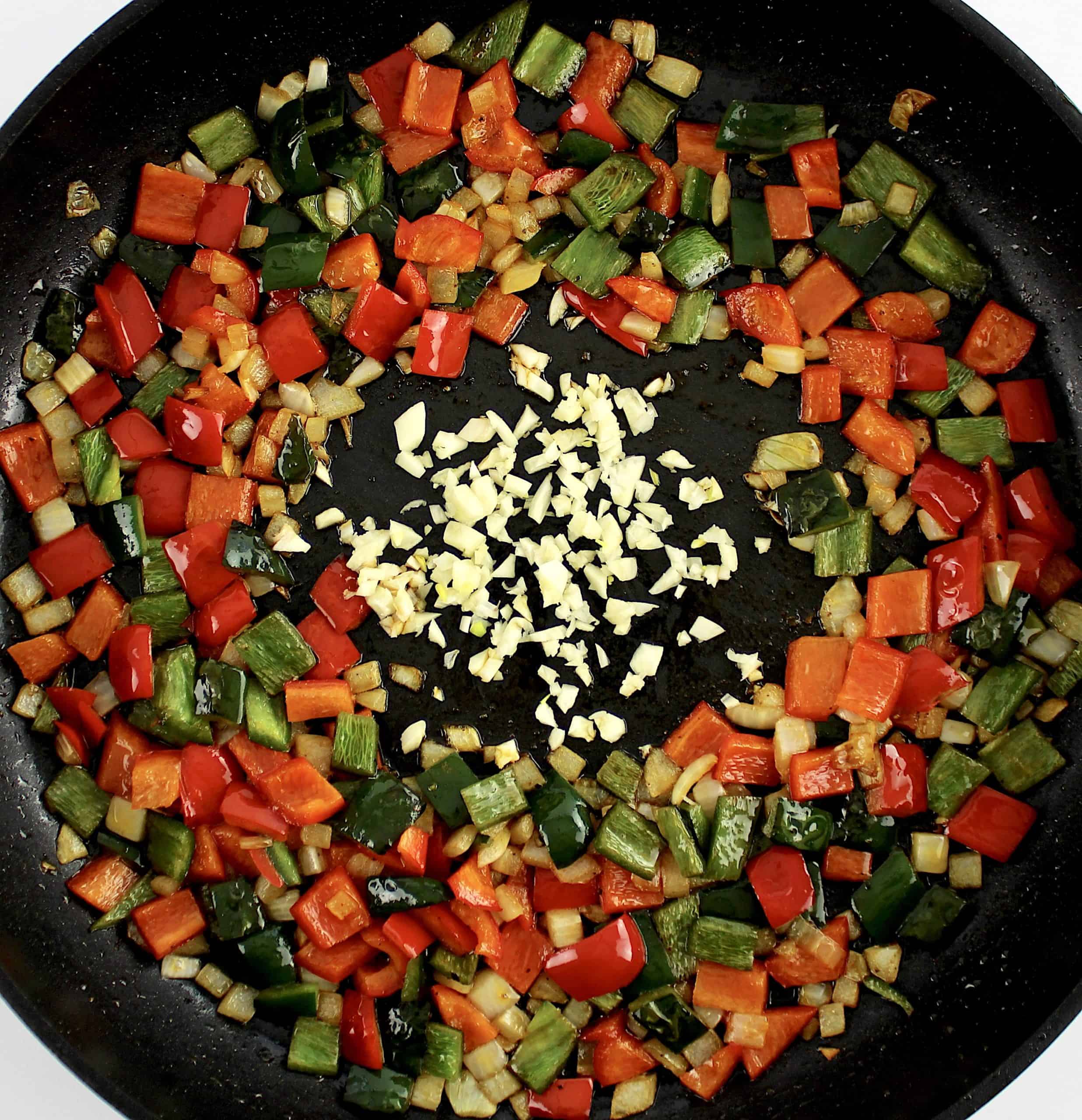 diced onion, red and poblano peppers in skillet cooked with minced garlic in center