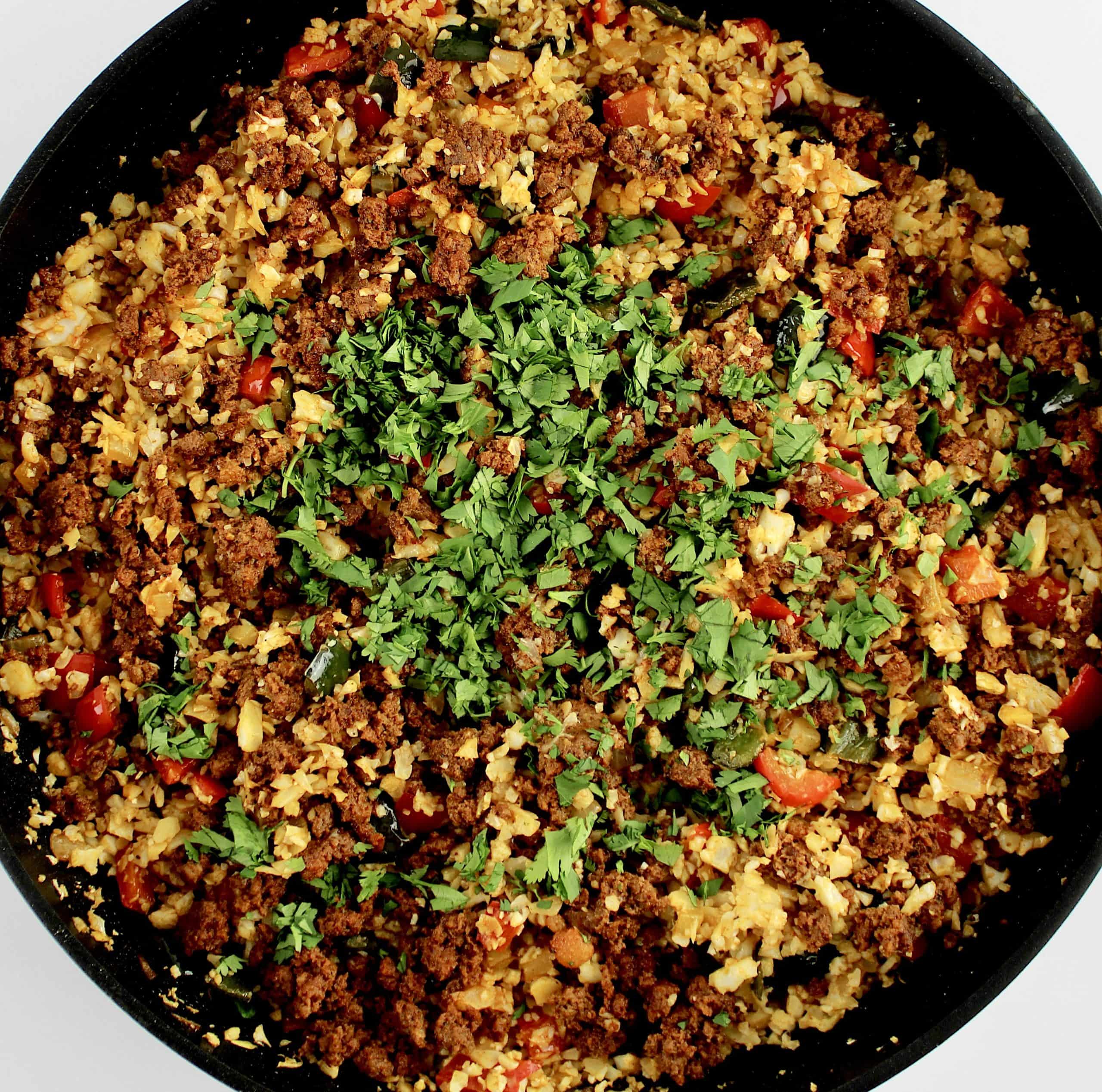 Chorizo and Pepper Cauliflower Rice with chopped cilantro on top in skillet