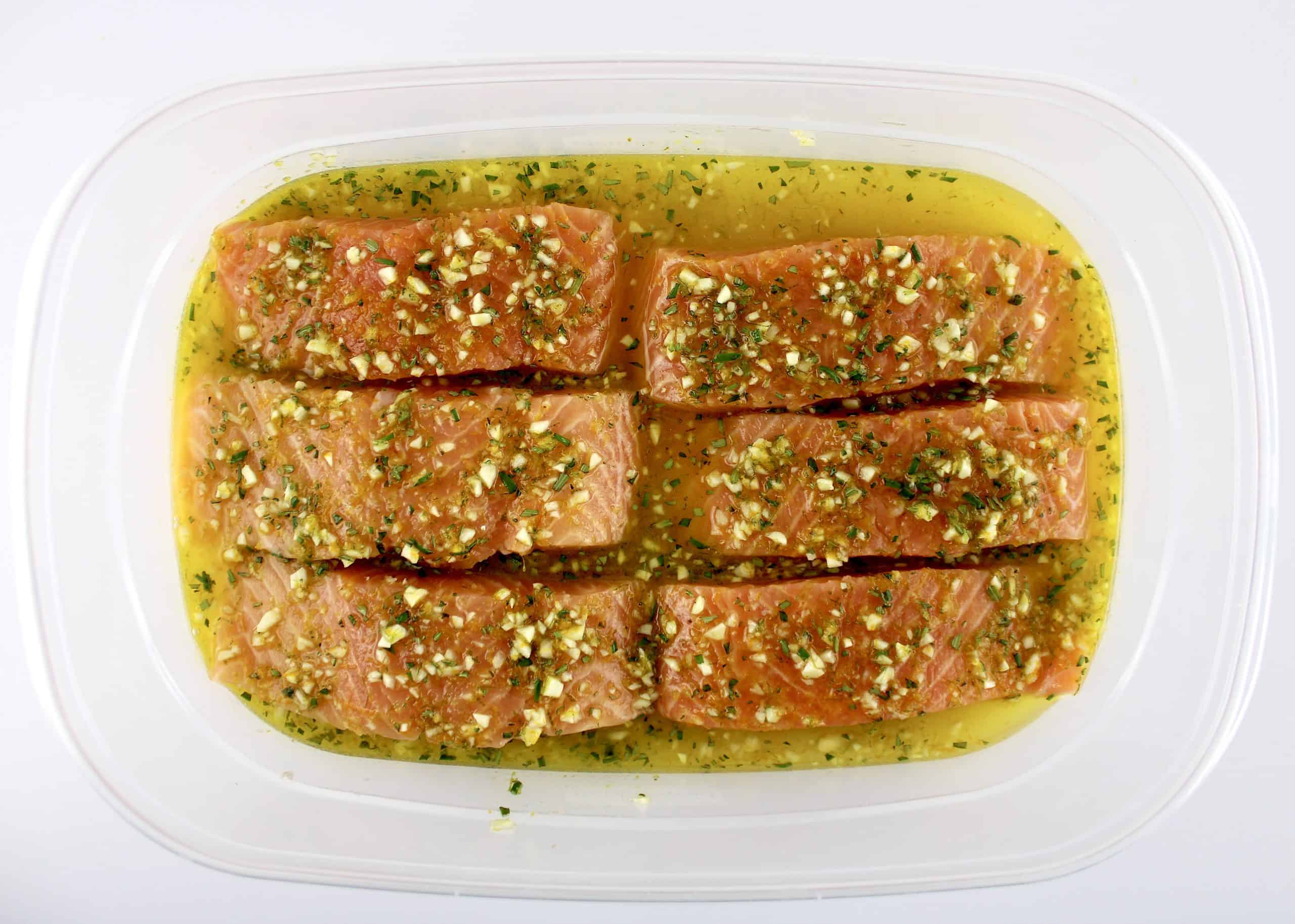 6 pieces of salmon in plastic container with citrus marinade