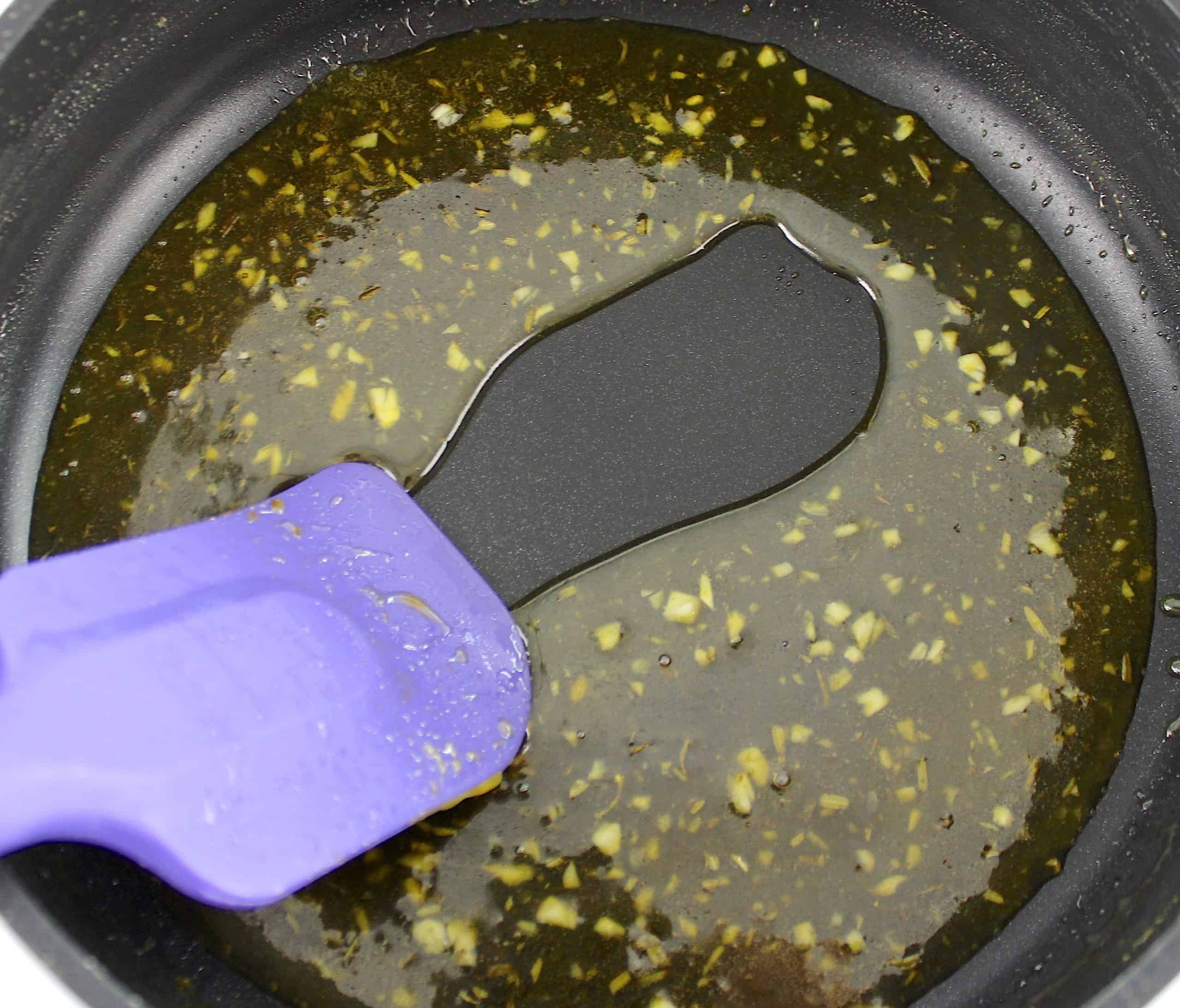 thickened citrus marinade glaze in saucepan with purple spatula