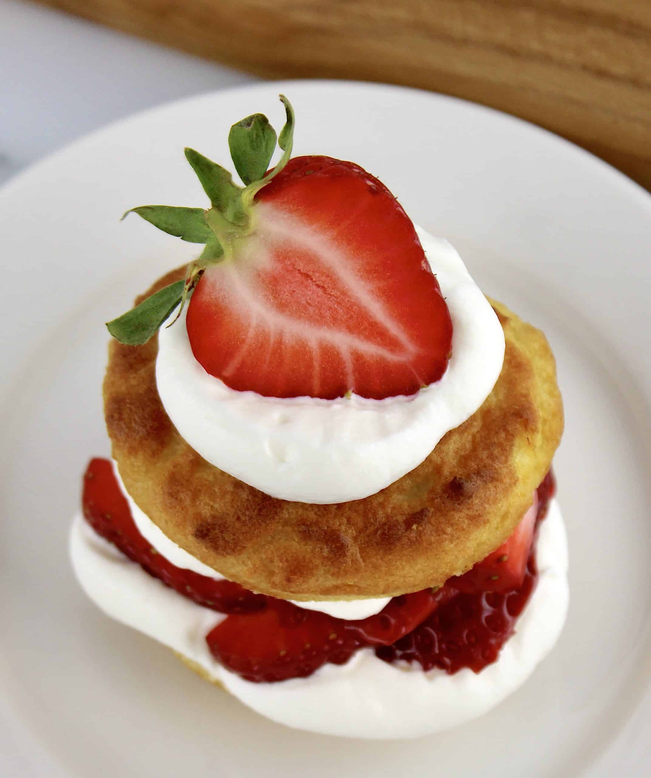 overhead view of Strawberry Shortcake on white plate with half strawberry on top