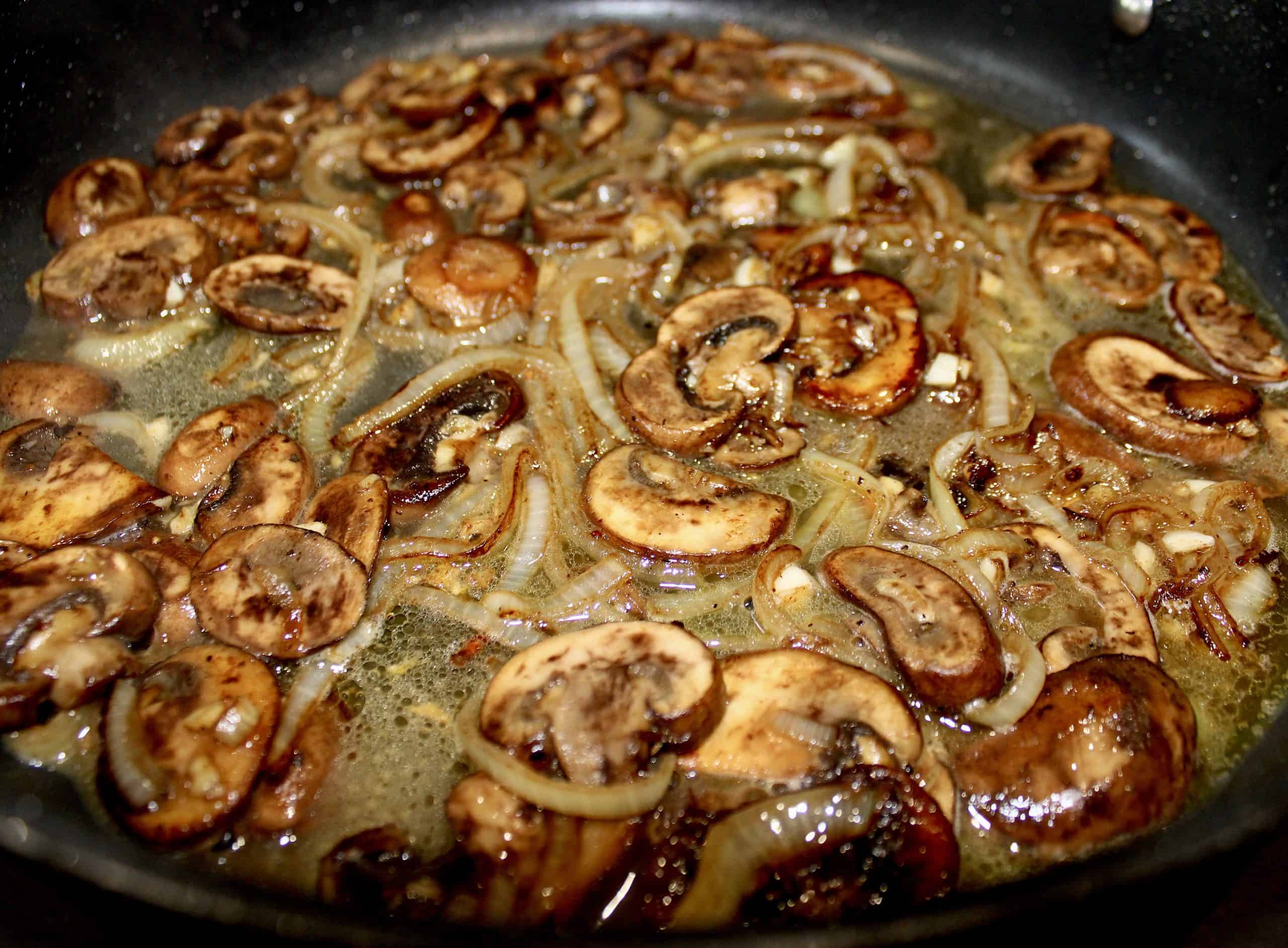 mushrooms onions garlic and white wine in skillet