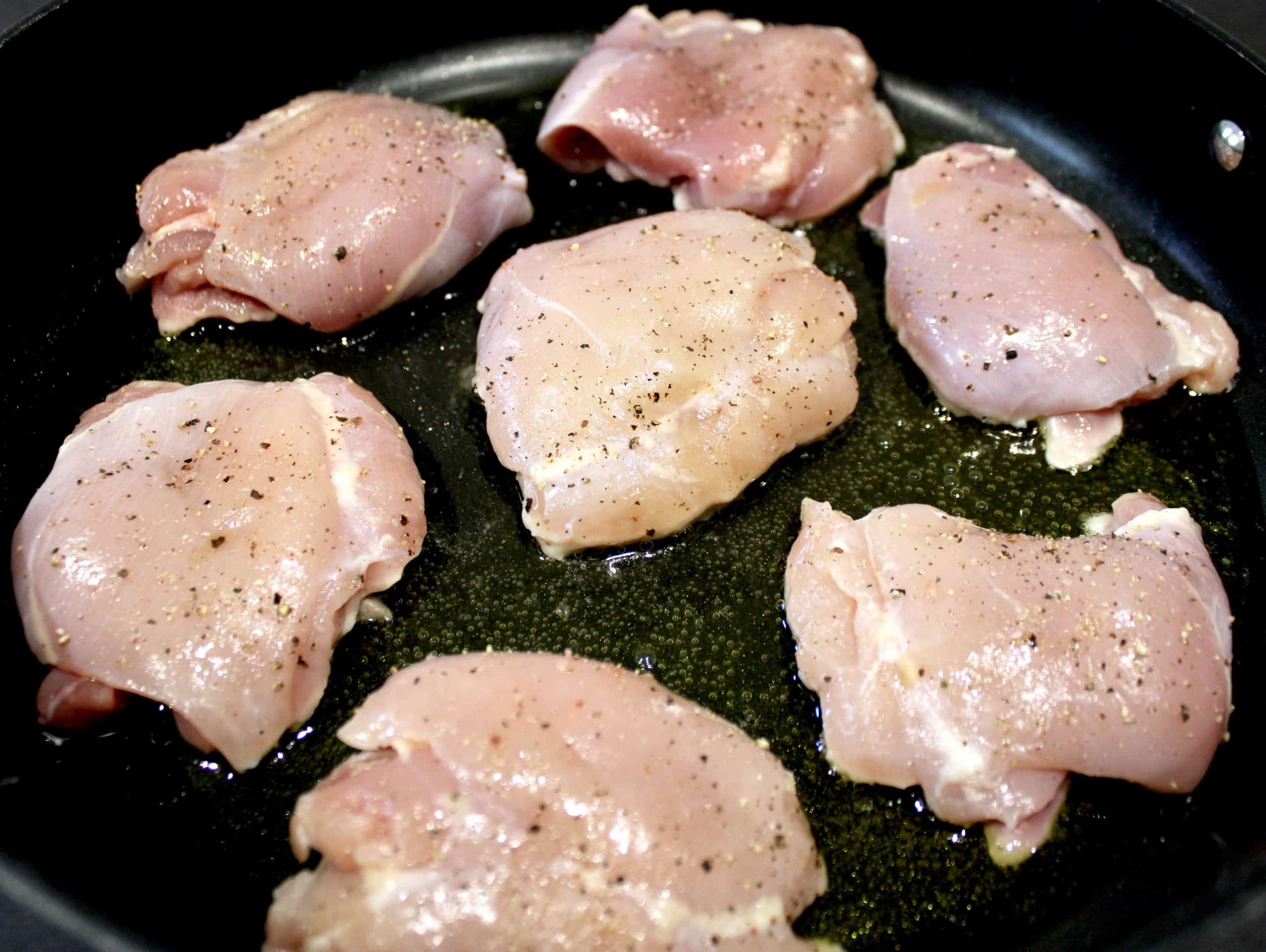 7 raw chicken thighs in skillet